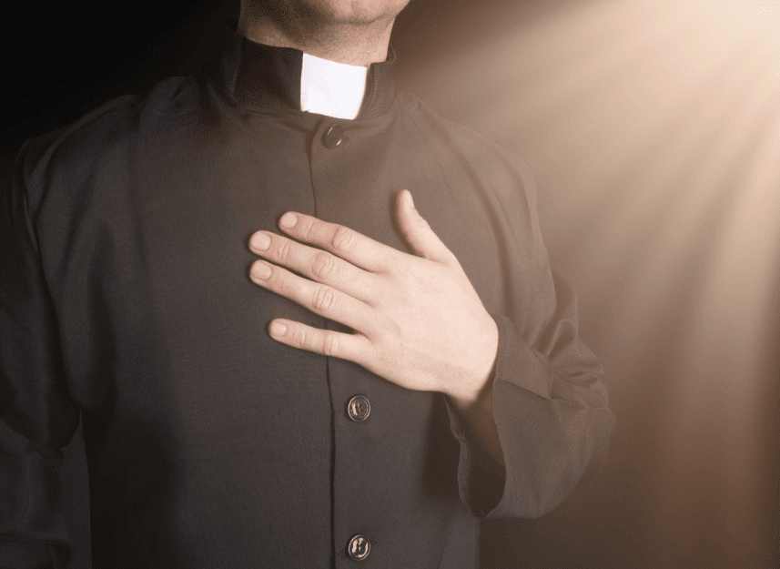 un homme d'église main sur le cœur | Photo : Shutterstock un homme d'église main sur le cœur | Photo : Shutterstock