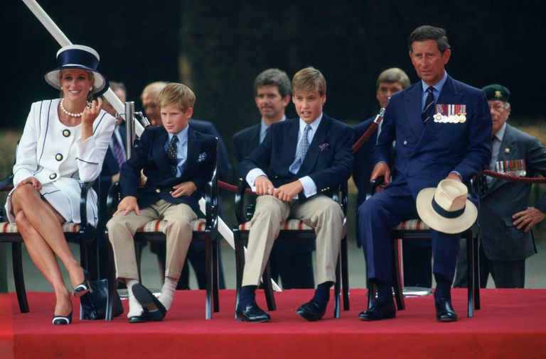 Le Prince Harry a enlevé ses chaussures en regardant le défilé du 50e anniversaire de la fête nationale. Il est assis avec sa famille - Diana, Princesse de Galles, Prince Charles et Prince William. | Source : Getty Images