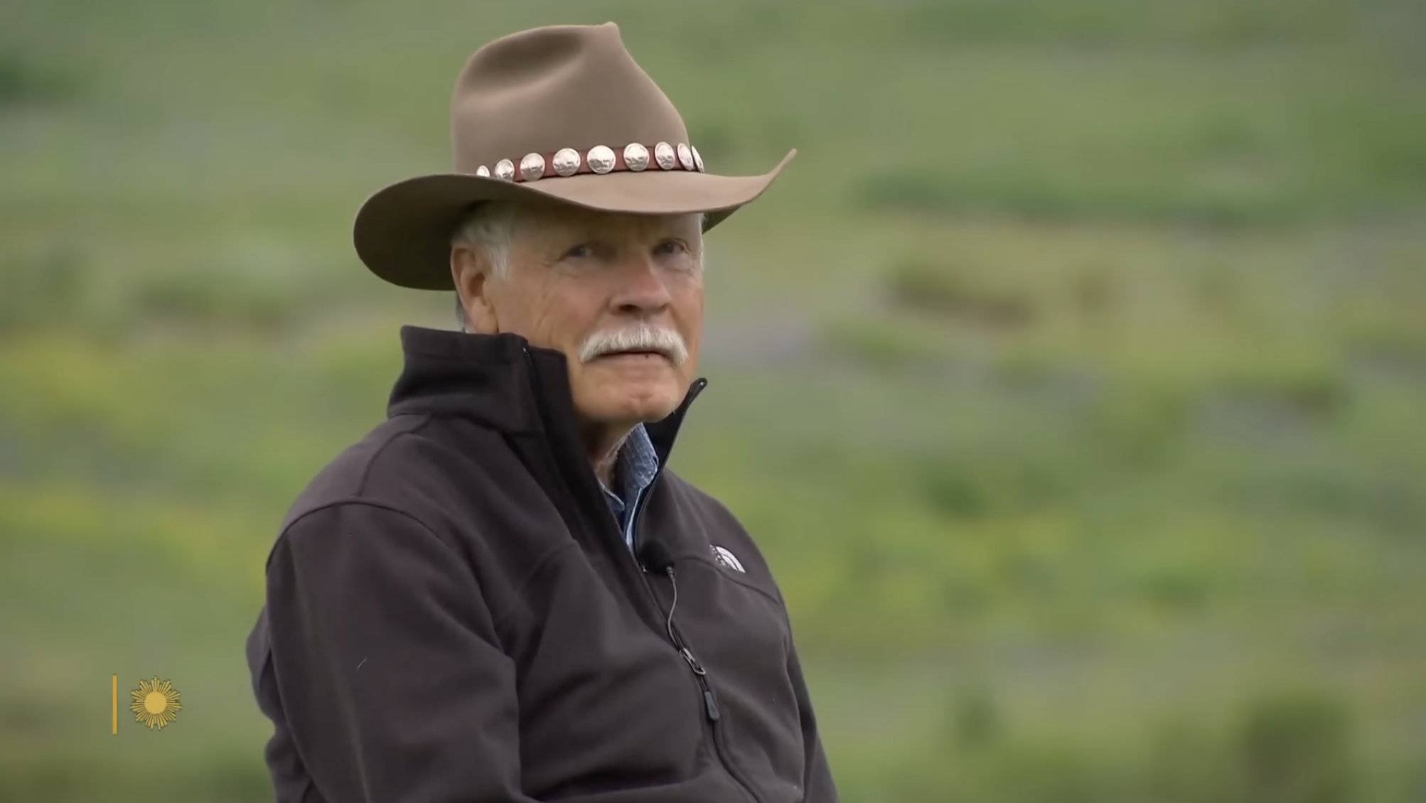 Wearing his signature cowboy hat, Ted Turner looks out across the open countryside during a moment captured on his conservation land. | Source: YouTube/CBS Sunday Morning