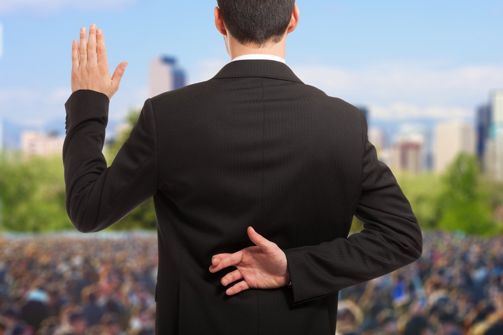 Político con los dedos cruzados detrás de la espalda. Fuente: Shutterstock