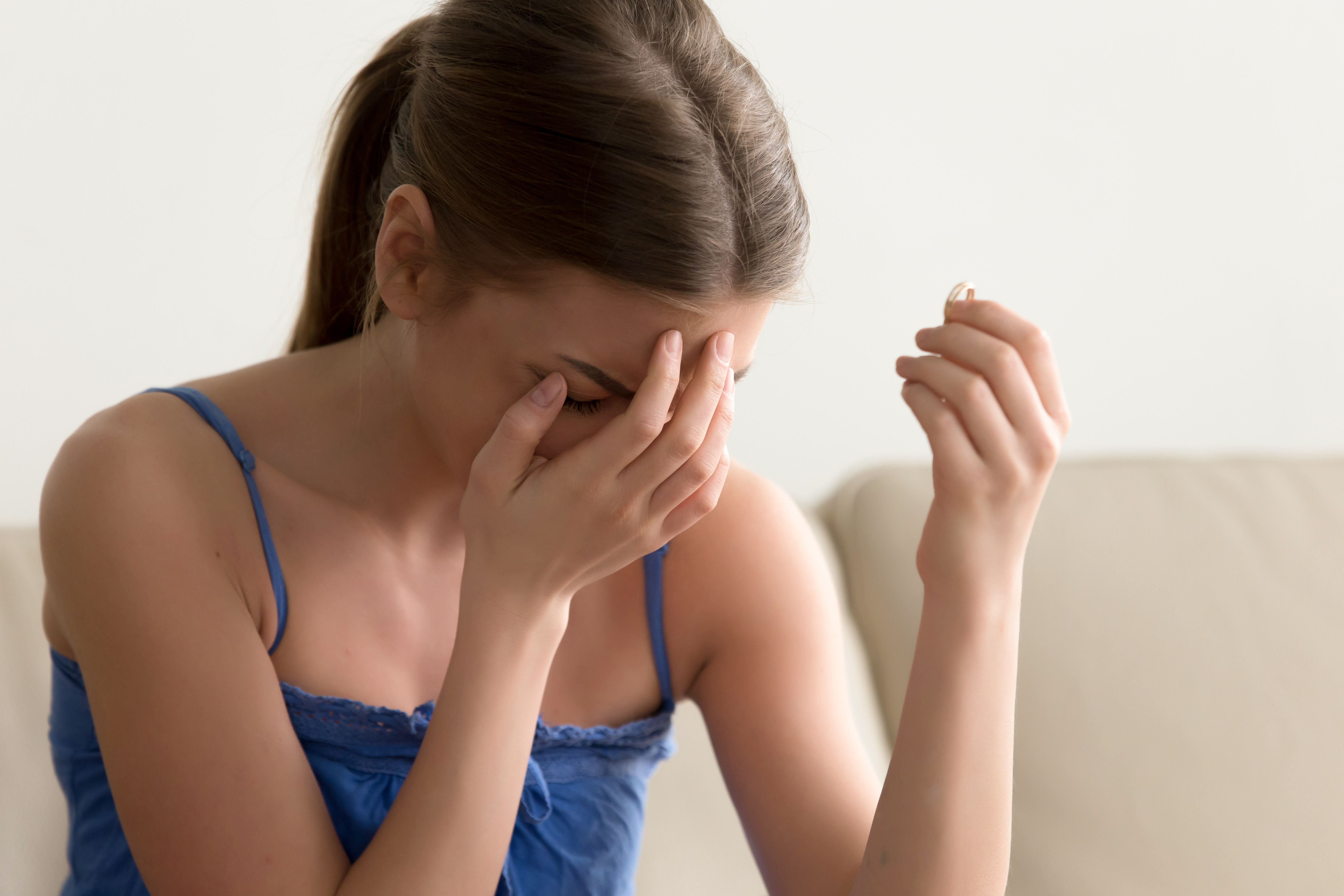 Woman crying while holding her engagement ring | Source: Shutterstock