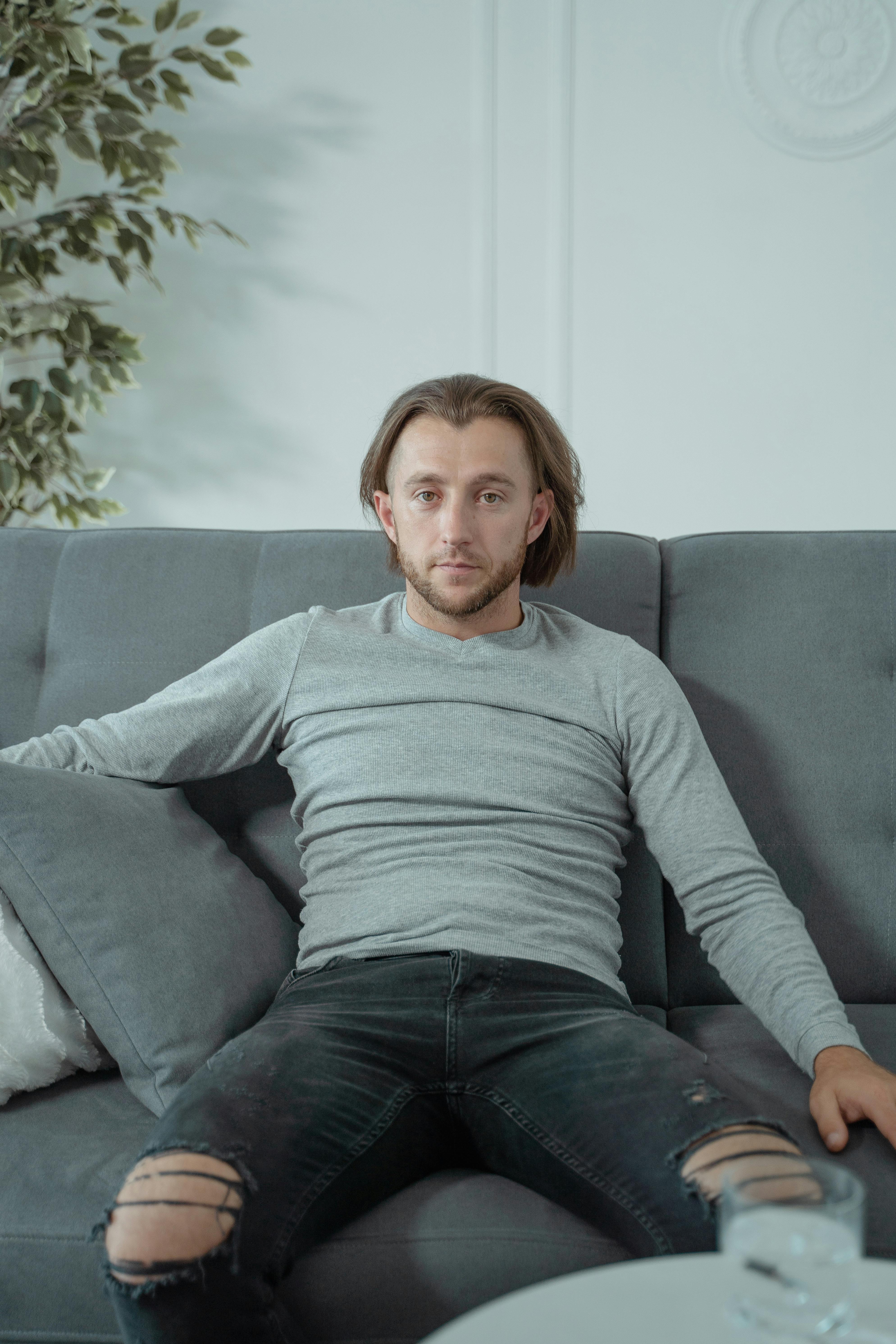 A focused man sitting on a couch | Source: Pexels