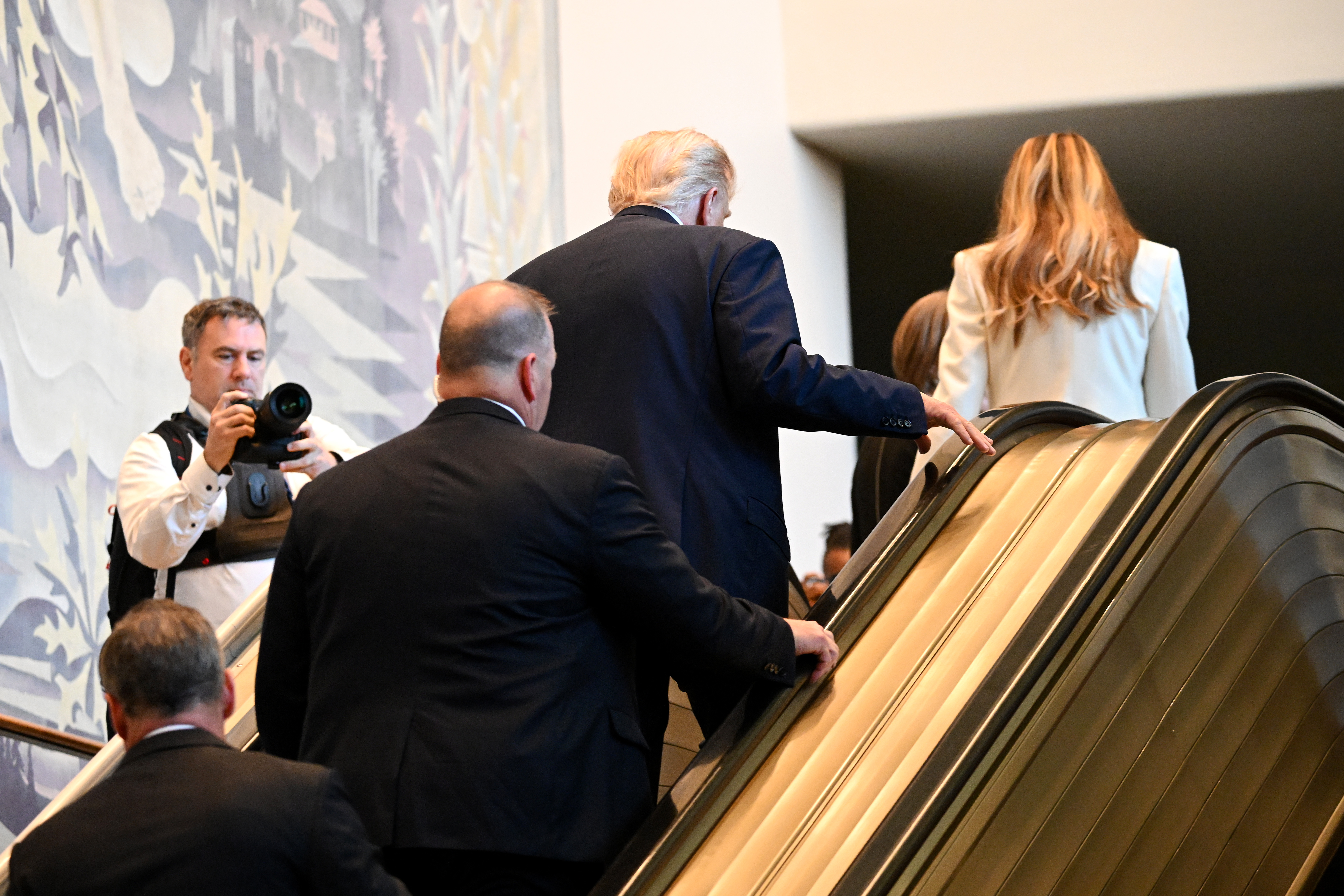Donald and Melania Trump at the top of the escalator with the U.S. delegation following behind. | Source: Getty Images