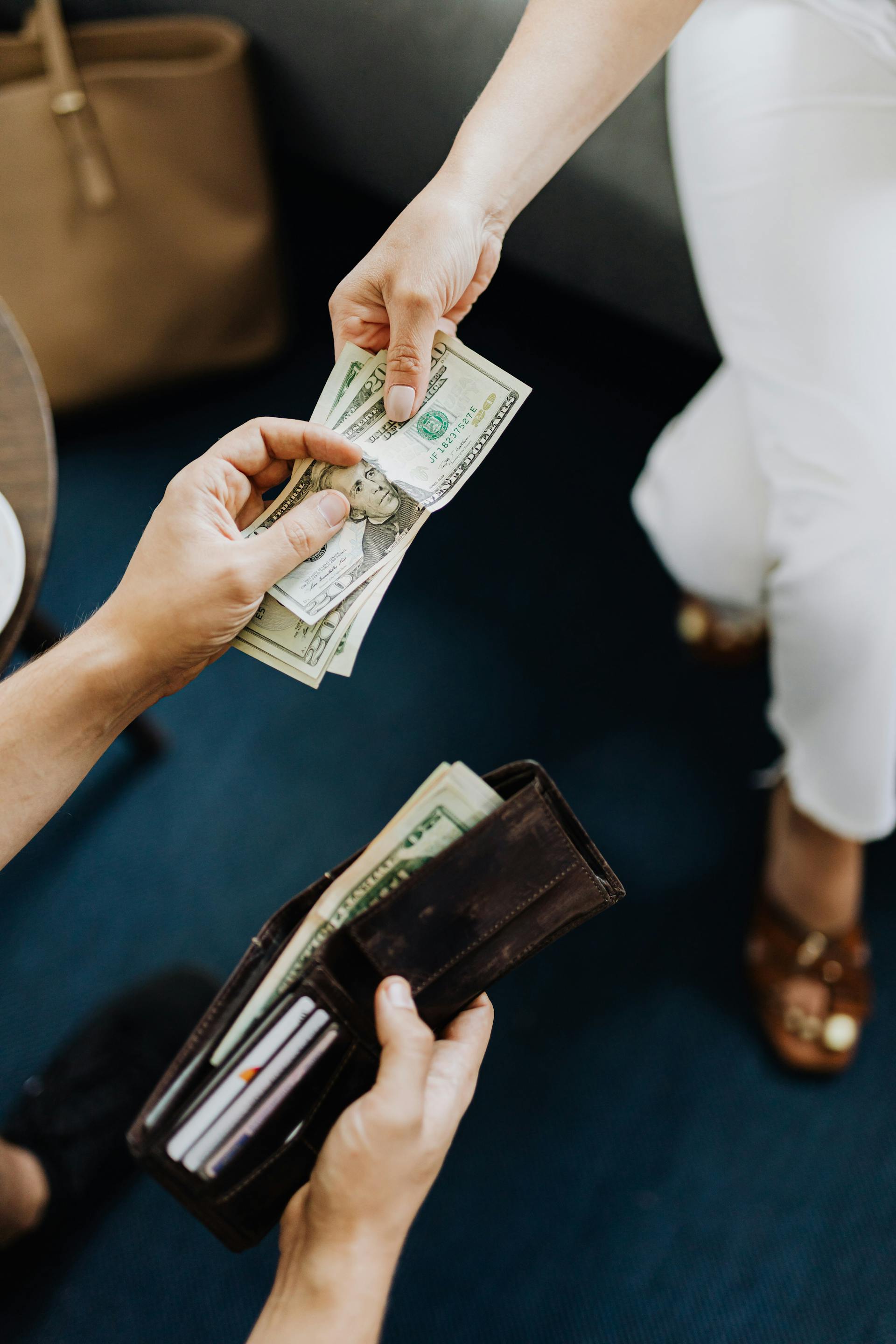 A closeup of a man paying money to a woman | Source: Pexels