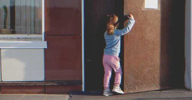 Una niña abriendo una puerta sola | Foto: Shutterstock