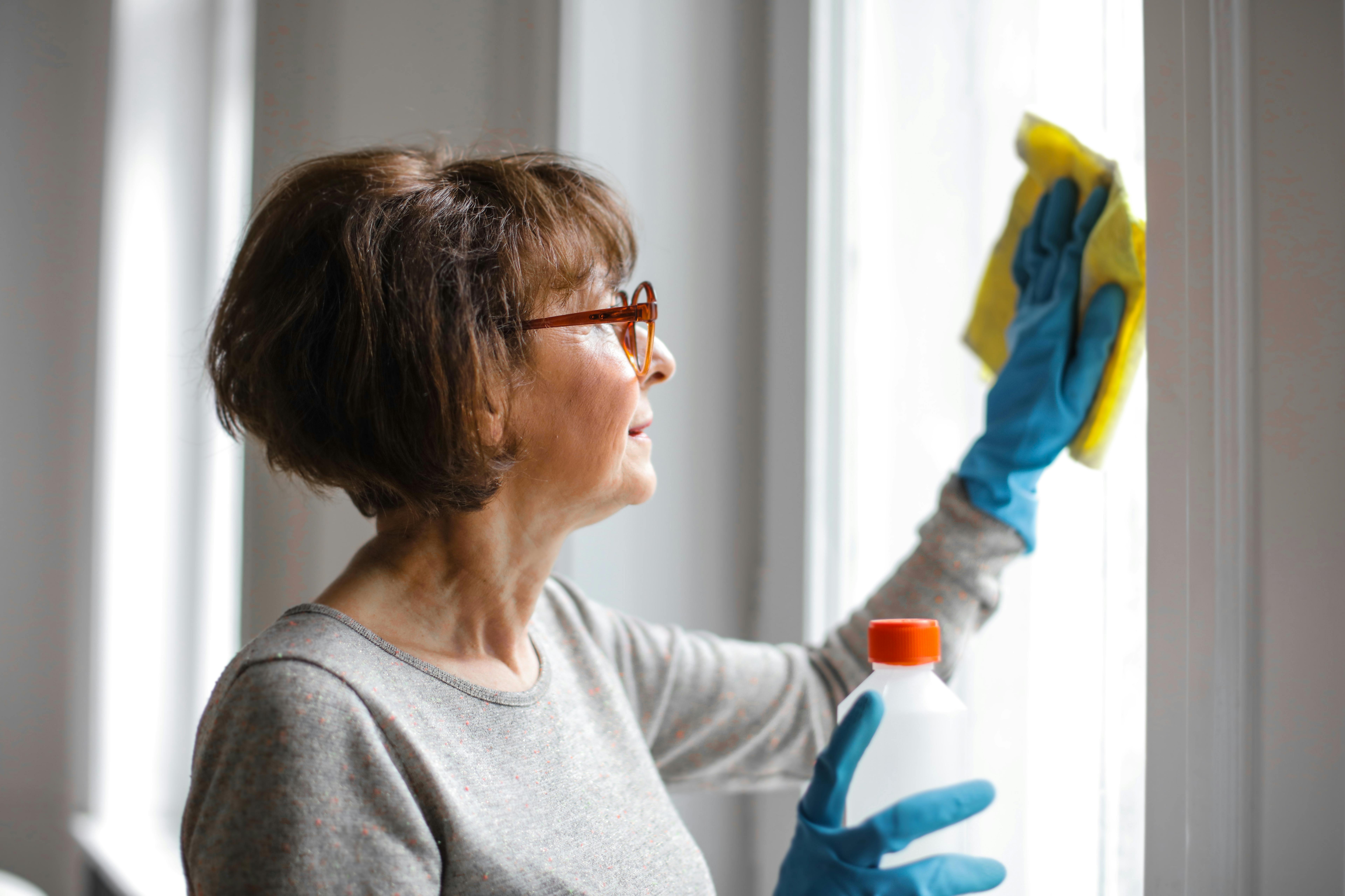 An older woman cleaning windows | Source: Pexels