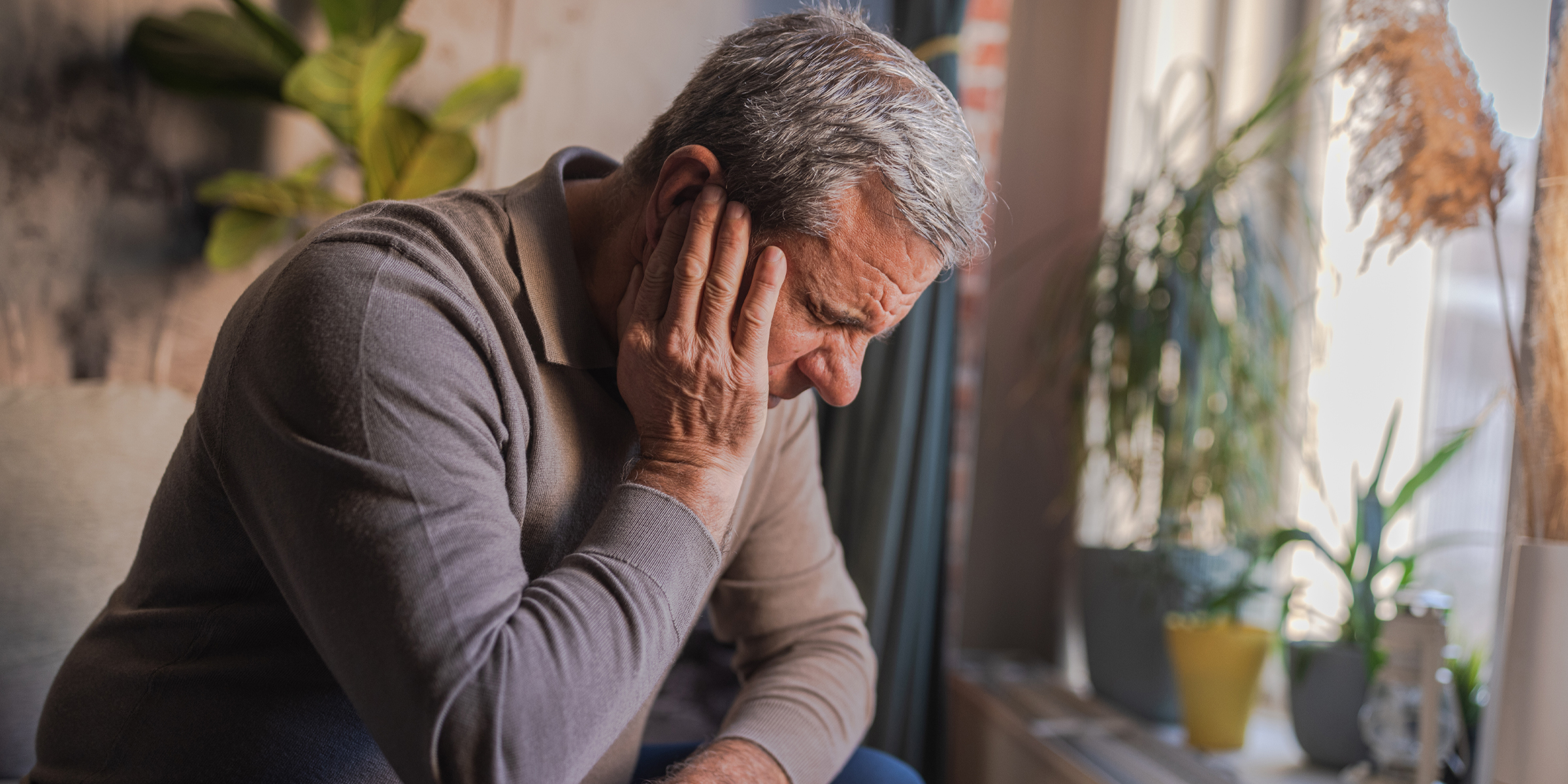 Man grimaces in pain from a severe earache | Source: Getty Images