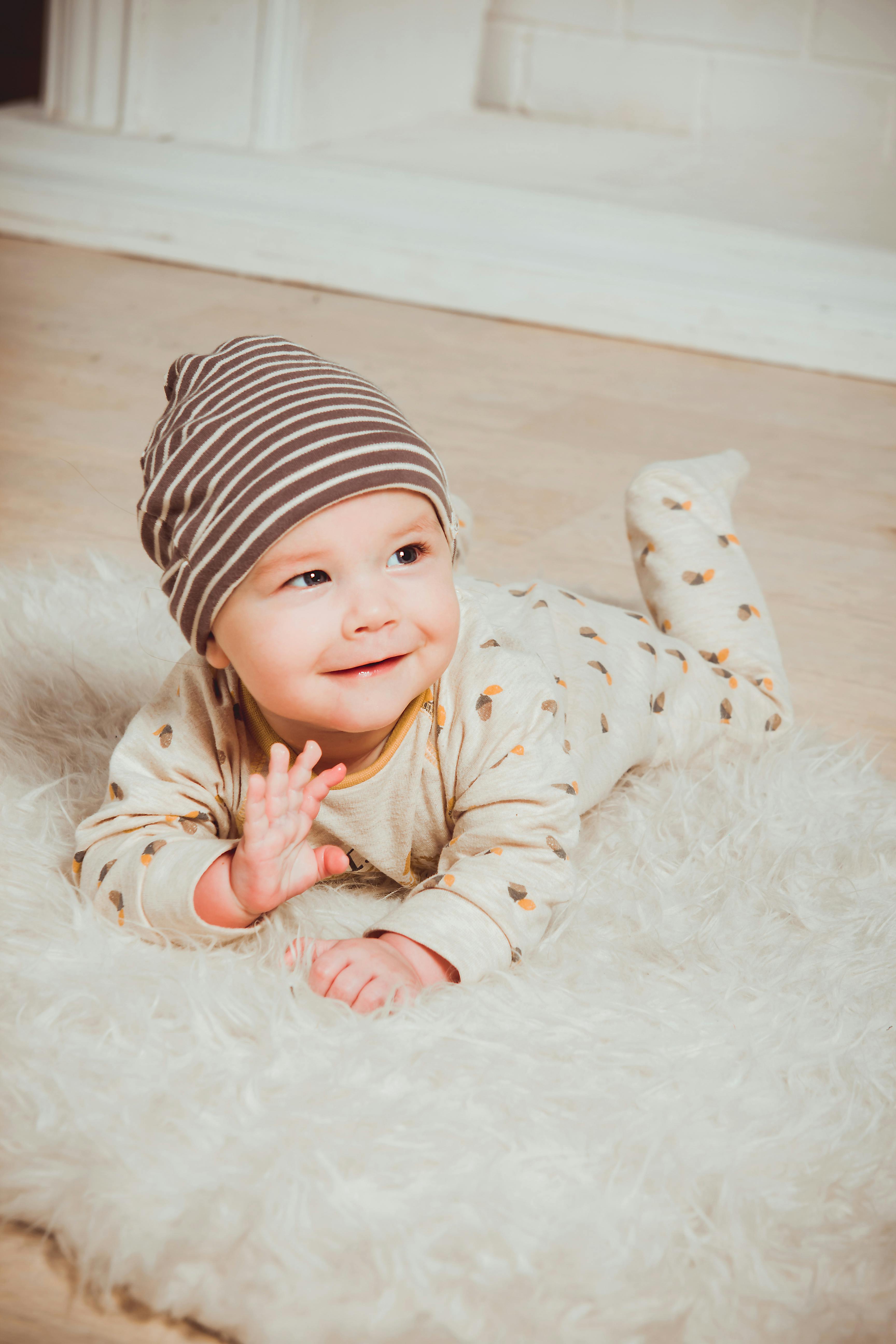 A smiling baby on a white mat | Source: Pexels