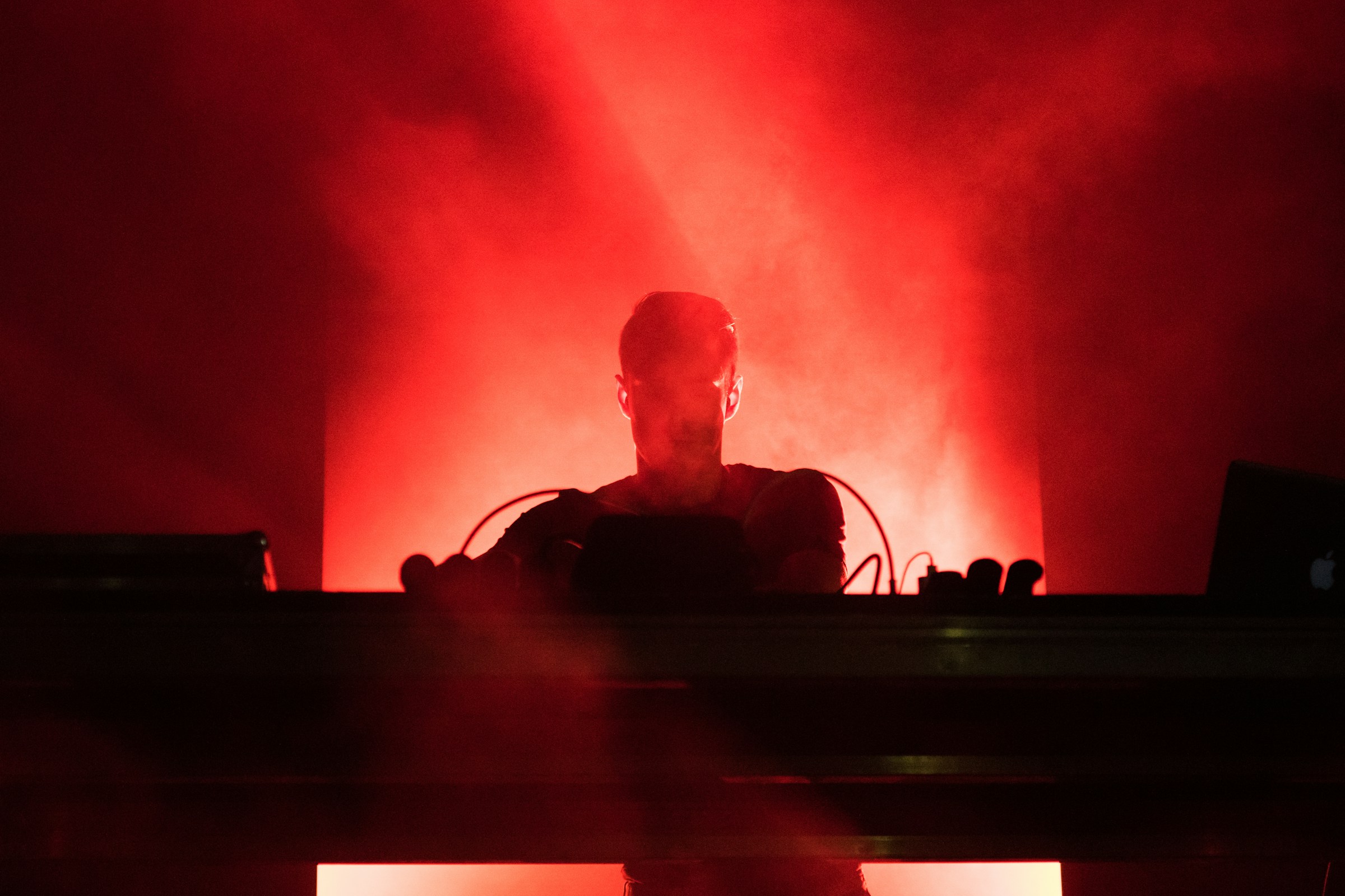 DJ playing music in red lights | Source: Unsplash