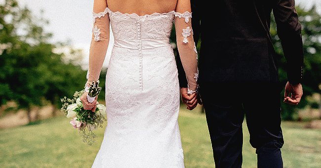 A bride and groom holding hands on their wedding day. | Source: Shutterstock