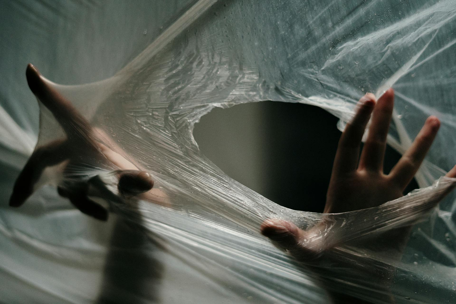 A person tearing through plastic wrap | Source: Pexels