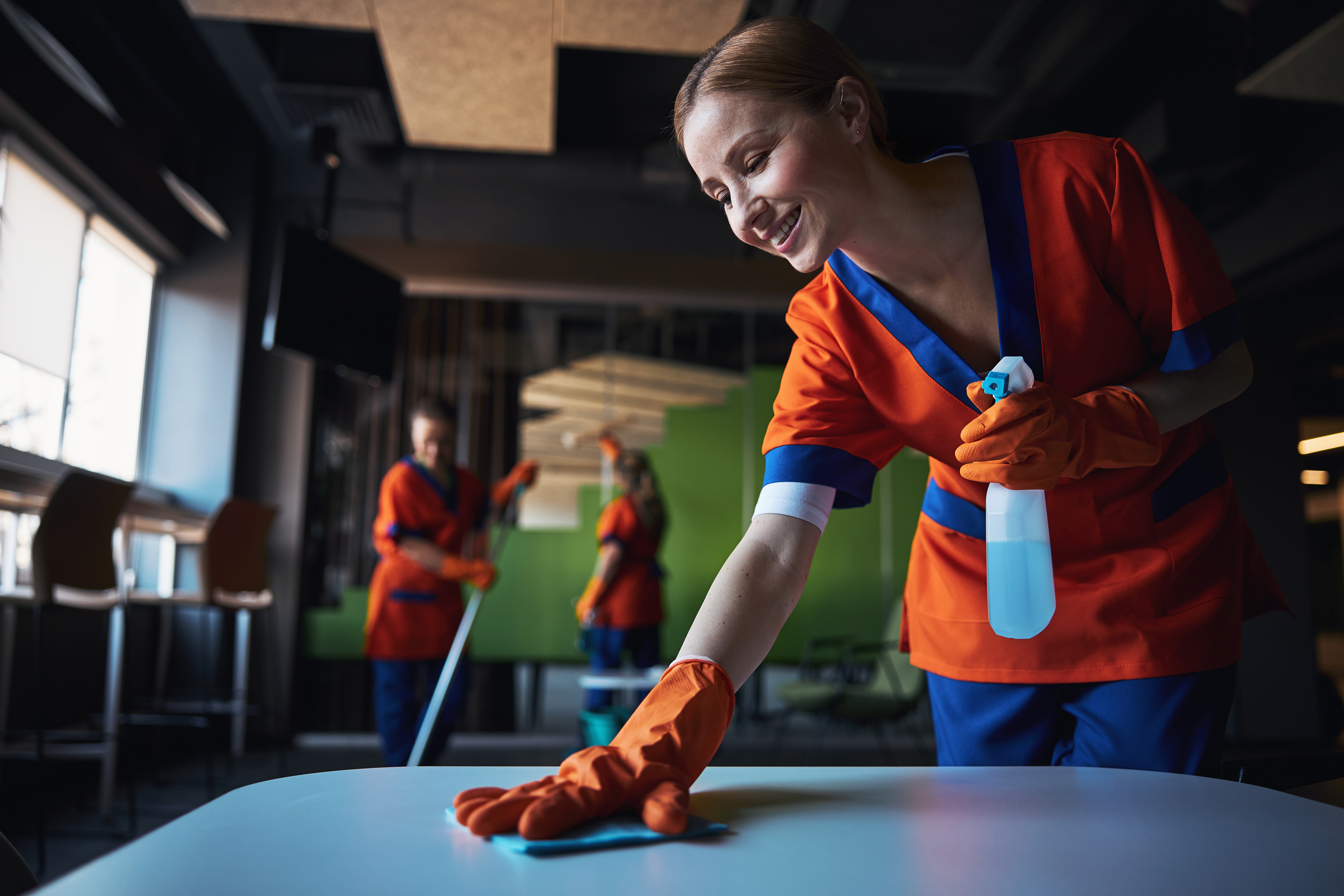 Three female workers using various janitorial supplies during the clean-up. | Source: Shutterstock