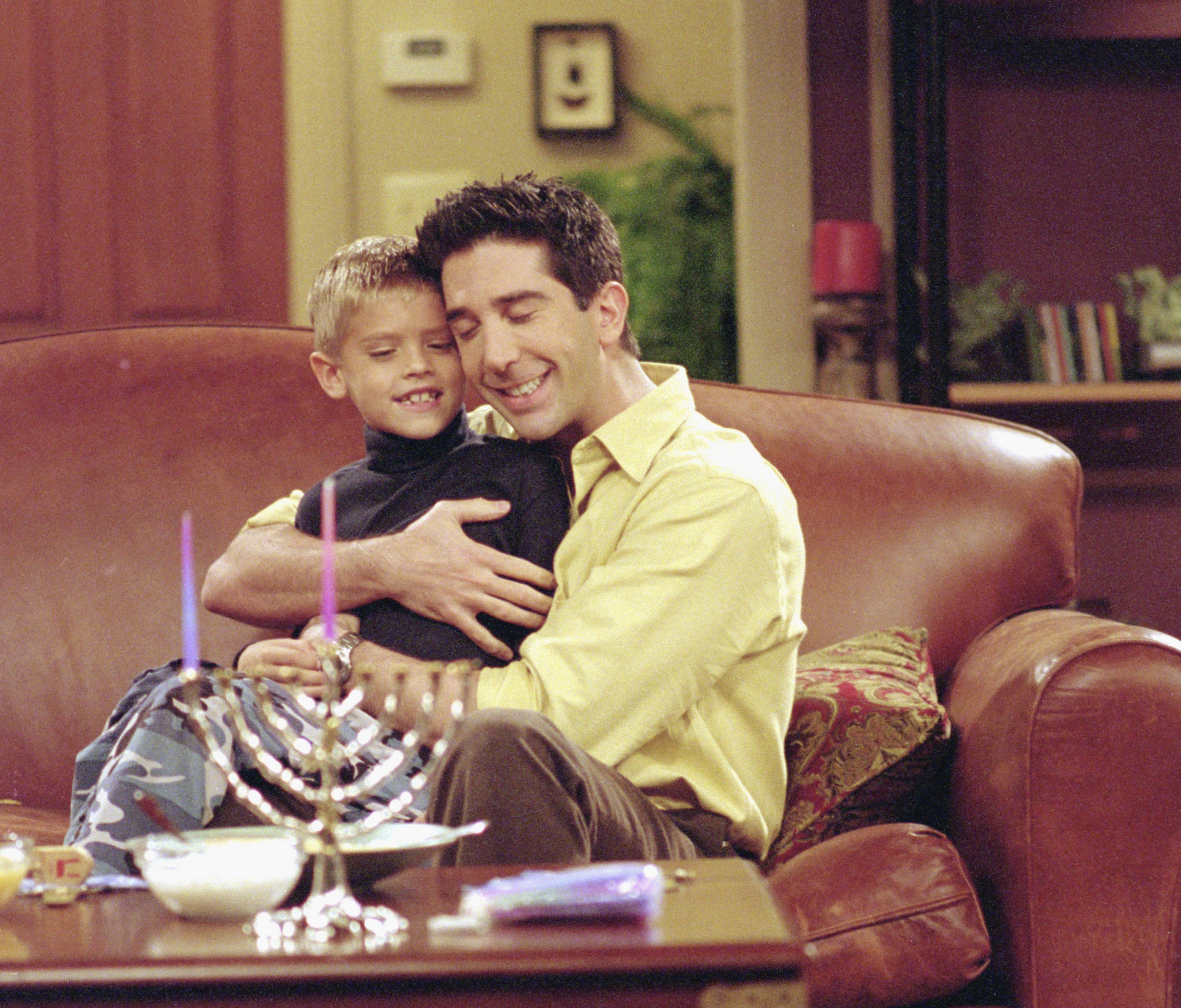 Cole Sprouse and David Schwimmer filming a scene in "Friends" in 2000. | Source: Getty Images