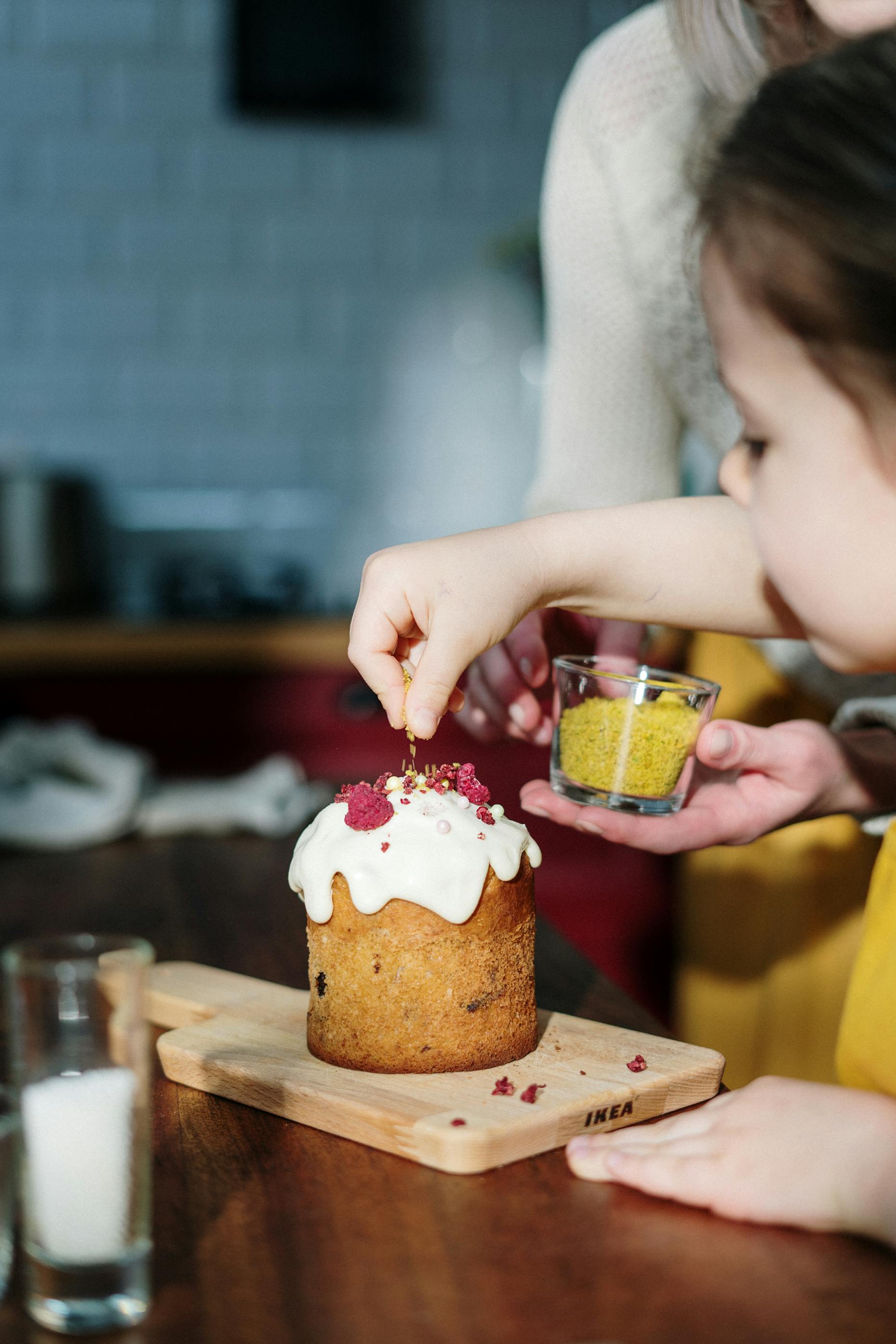 A little girl decorating a cake | Source: Pexels