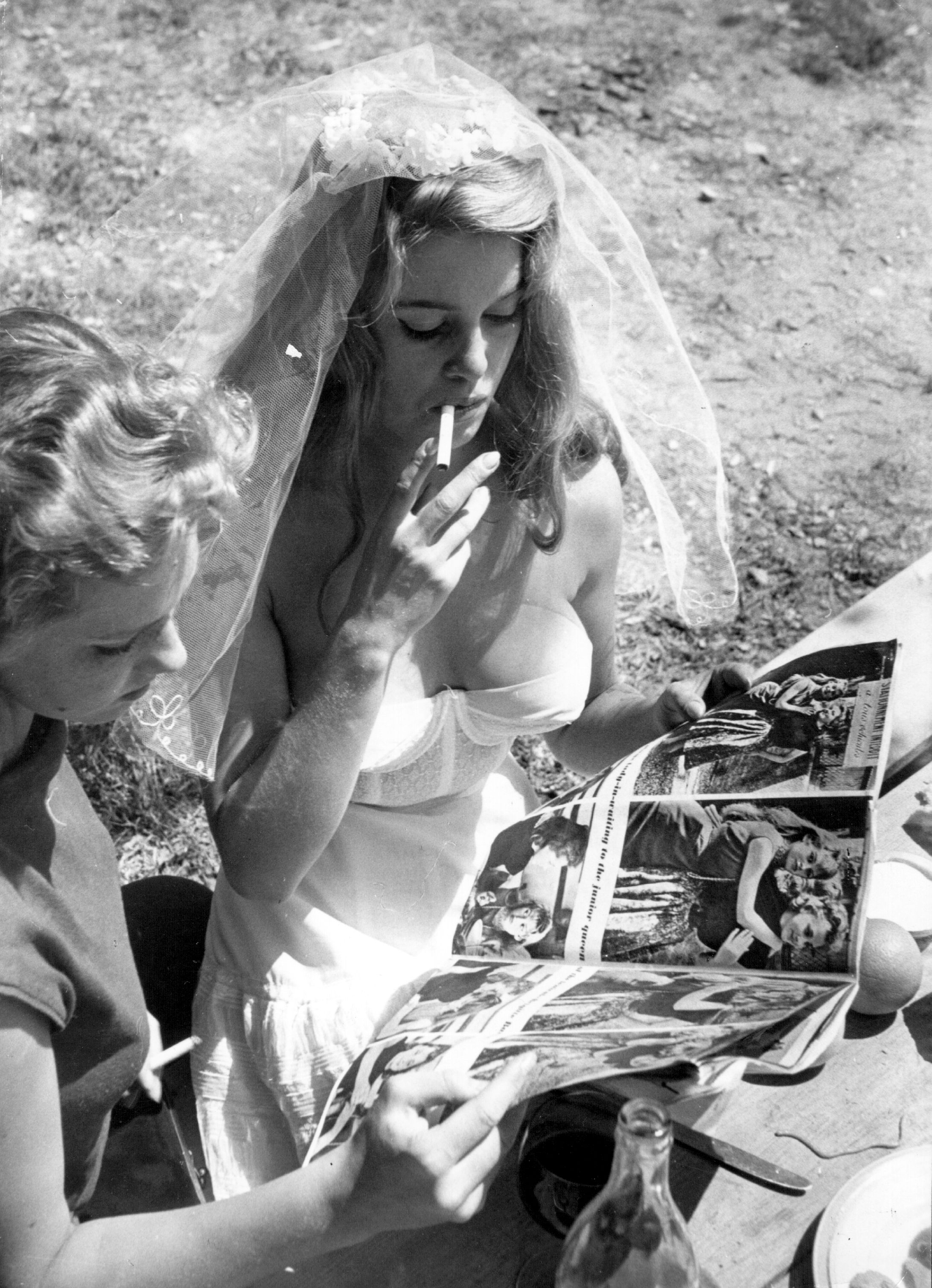 Brigitte Bardot taking a smoking break while filming "And God Created Woman" on July 1, 1956, in San Tropez, France. | Source: Getty Images
