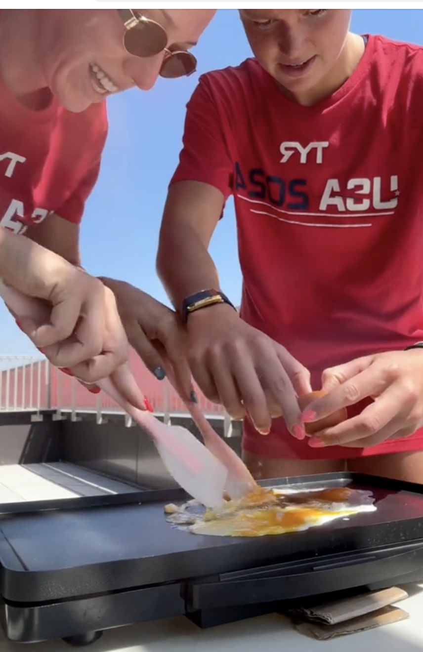 A screenshot of Abbey Weitzeil and Phoebe Bacon cooking eggs in their room at the Olympic Village | Source: TikTok/abbeyweitzeil