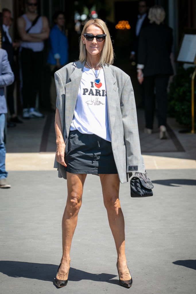 Céline Dion arborant une veste grise ... une minie jupe noire / Source : Getty images