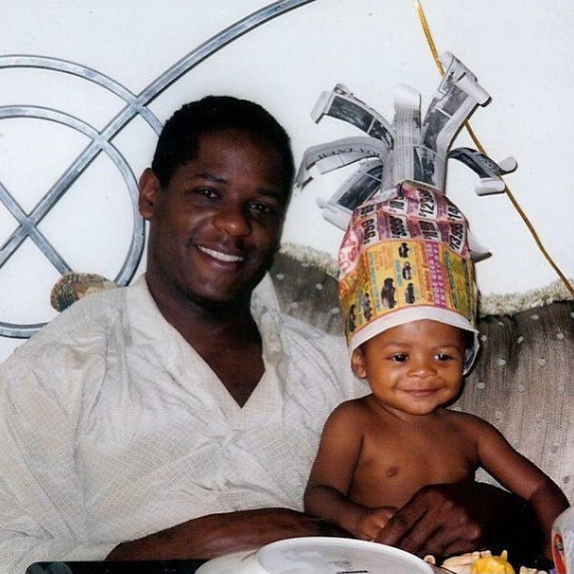 Blair Underwood smiles while holding a young Blake Underwood, who wears a playful homemade hat, capturing a warm and lighthearted family moment together. | Source: Instagram/blairunderwood_official