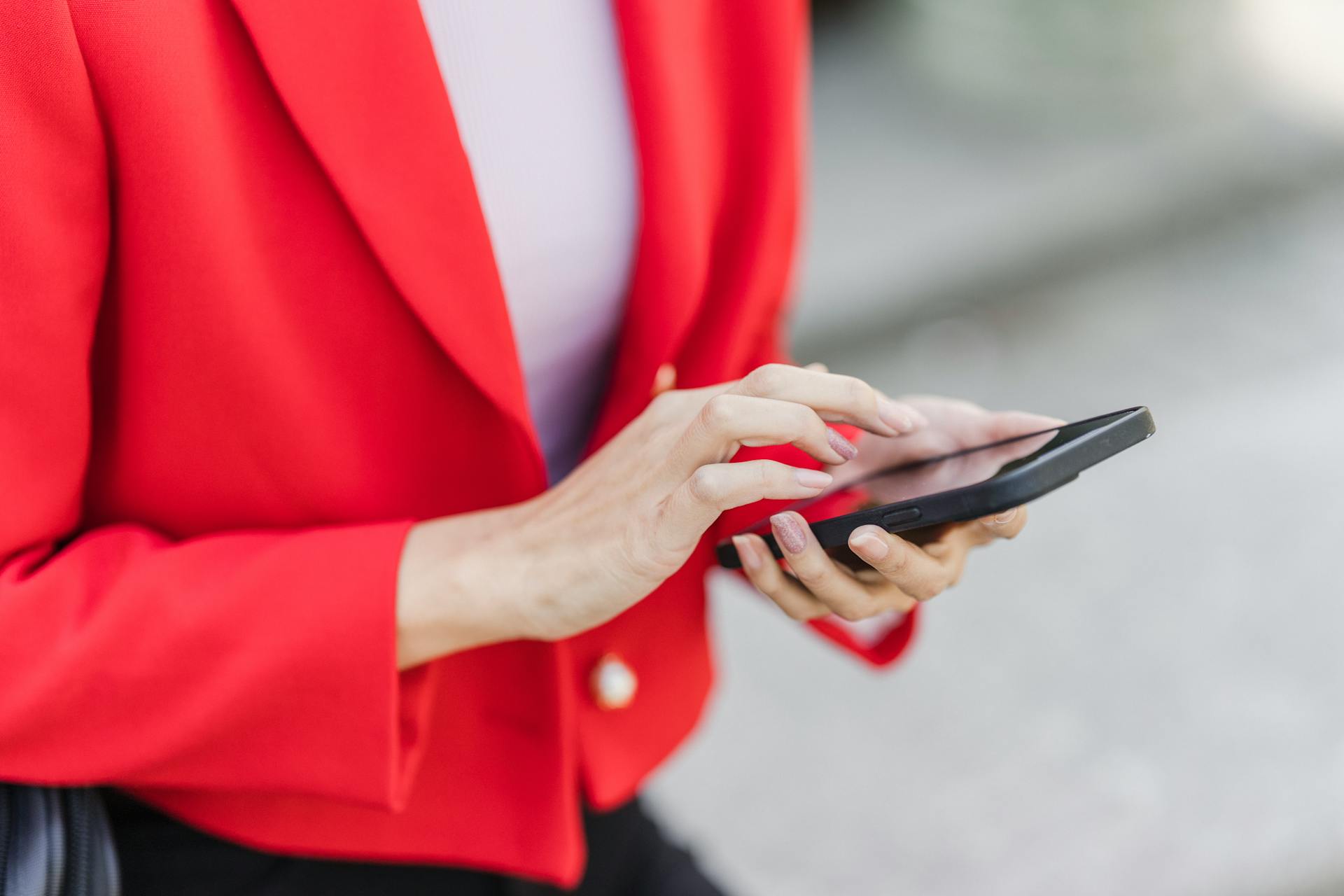 A woman holding a smartphone | Source: Pexels