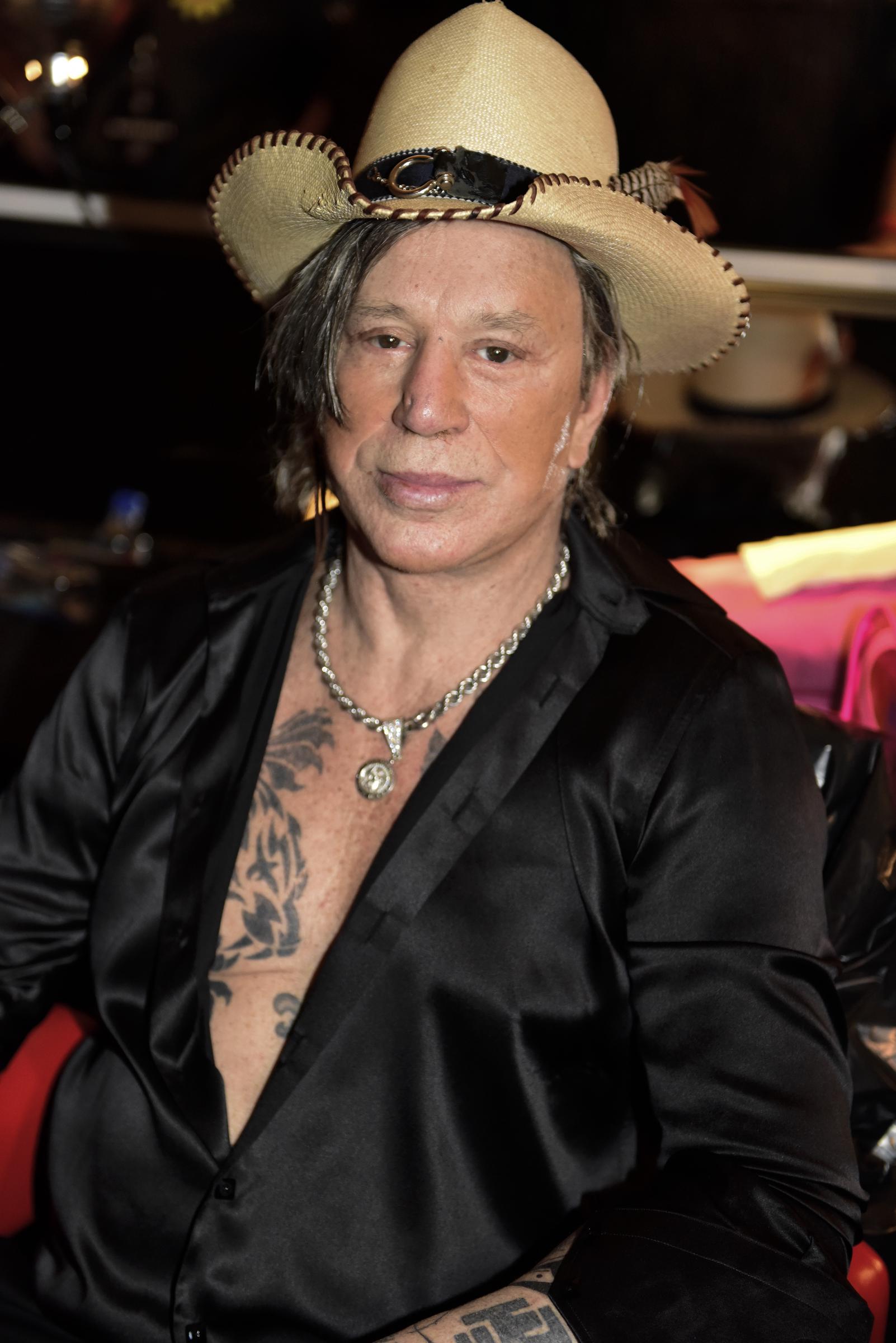 Backstage at the Philipp Plein and Billionaire Fall/Winter 2019 show during New York Fashion Week, Mickey Rourke posed in an open black satin shirt that revealed his chest tattoos and layered silver necklaces. Photographed on February 11, 2019, he completed the look with a statement cowboy hat as he took in the fashion event away from the runway.