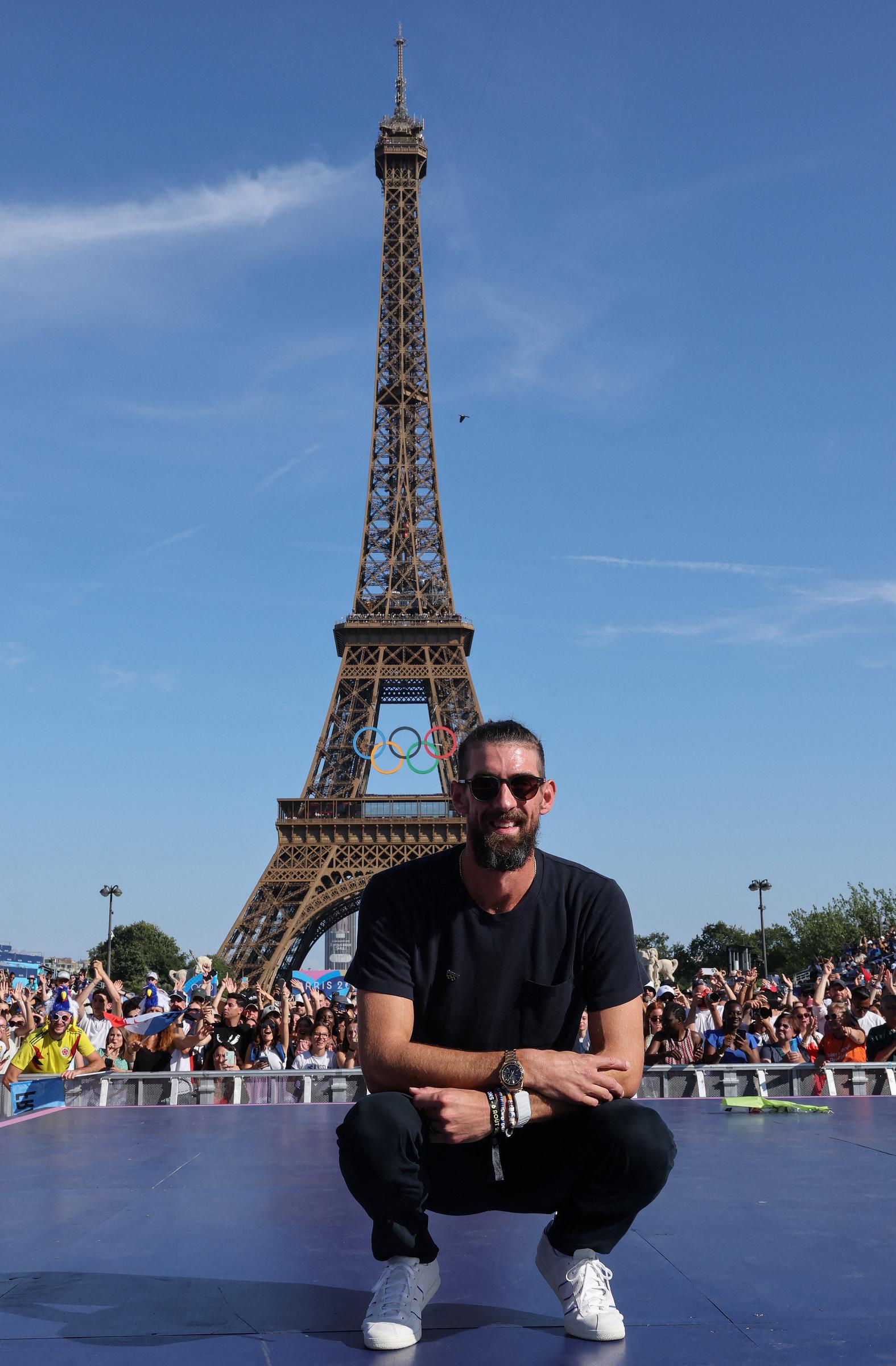 Michael Phelps poses on stage during the Paris 2024 Olympic Games with the Eiffel Tower visible in the background, at the Champions Park at Trocadero in Paris, on August 6, 2024.