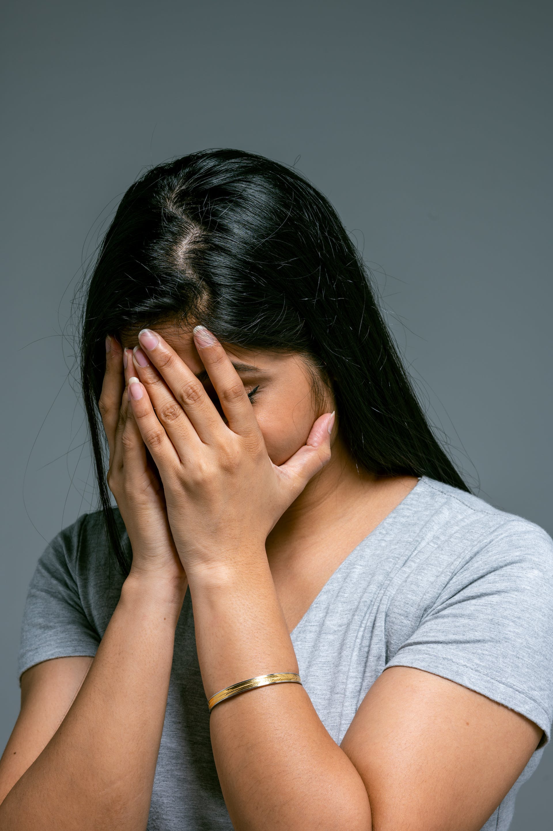 A woman covering her face with her hands | Source: Pexels