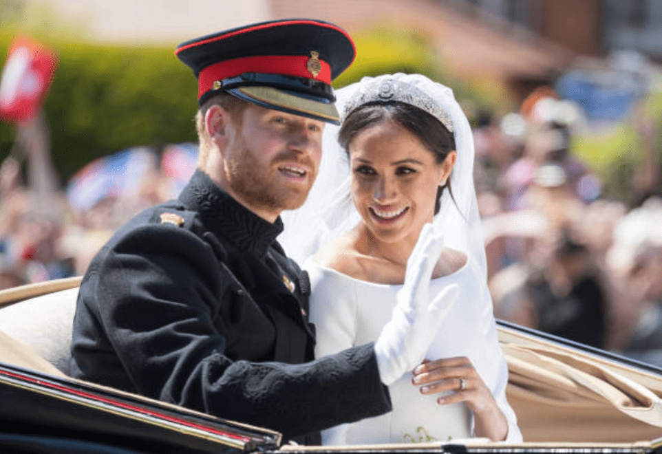 Le prince Harry et Meghan Markle saluent le public alors qu'ils se déplacent en calèche | Source: Getty Images Le prince Harry et Meghan Markle saluent le public alors qu'ils se déplacent en calèche | Source: Getty Images