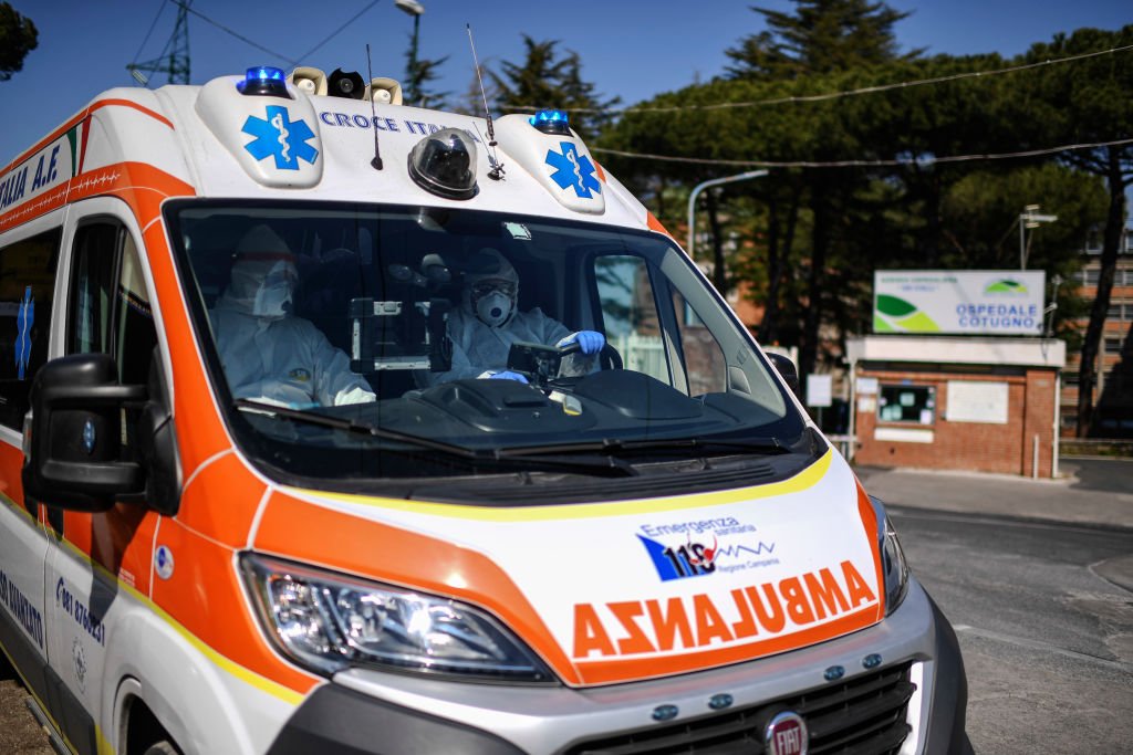 Des ambulanciers paramédicaux à bord d'une ambulance à haut confinement biologique sortent des urgences de l'hôpital Cotugno à Naples. | Photo : Getty Images.