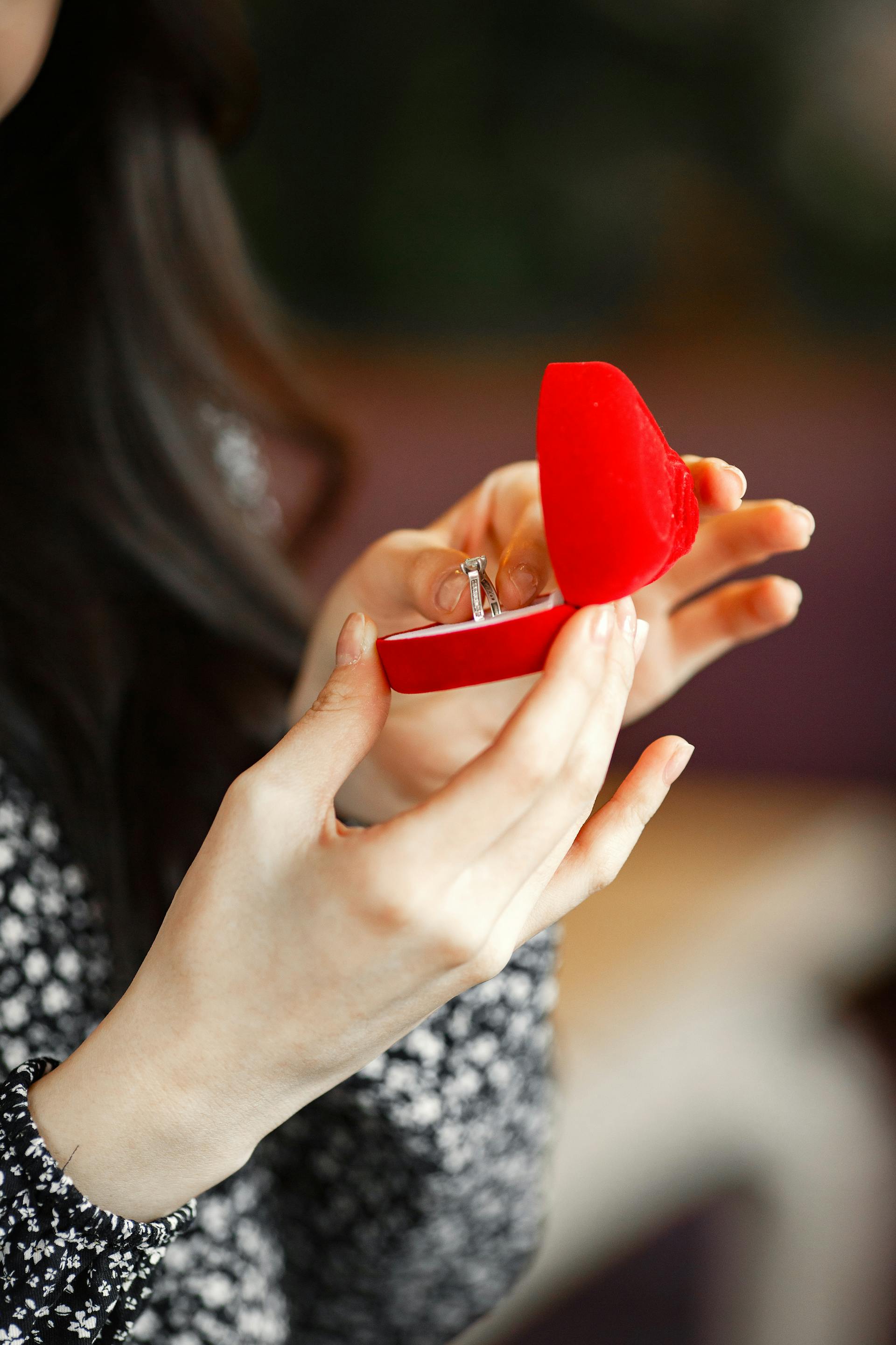 A closeup shot of a woman holding a box with an engagement ring inside | Source: Pexels