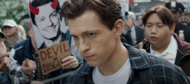 Peter Parker walking by a group of people protesting against him | Photo: Youtube.com/Marvel Entertainment