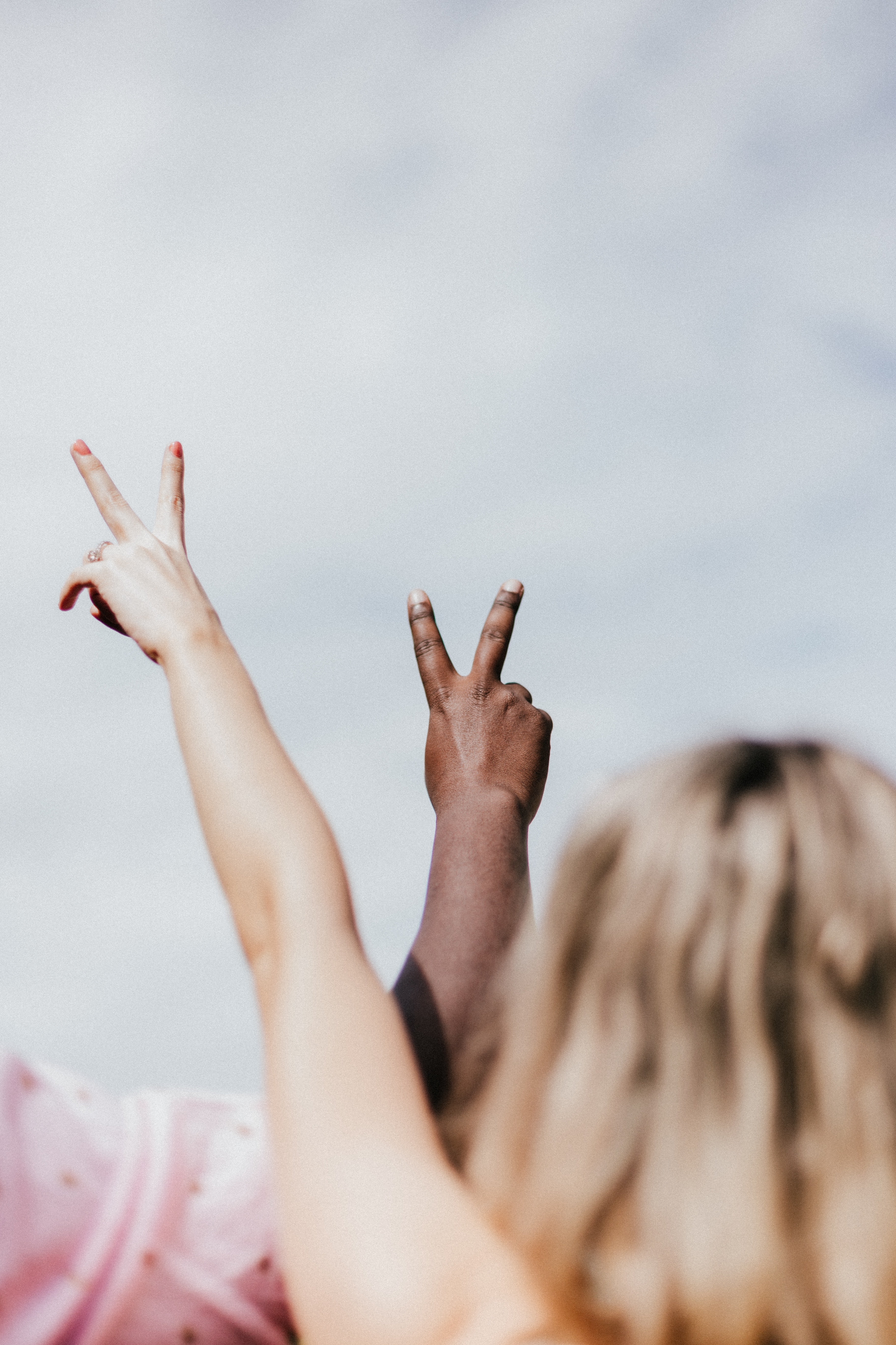 Two individuals holding up a peace sign | Source: Unsplash