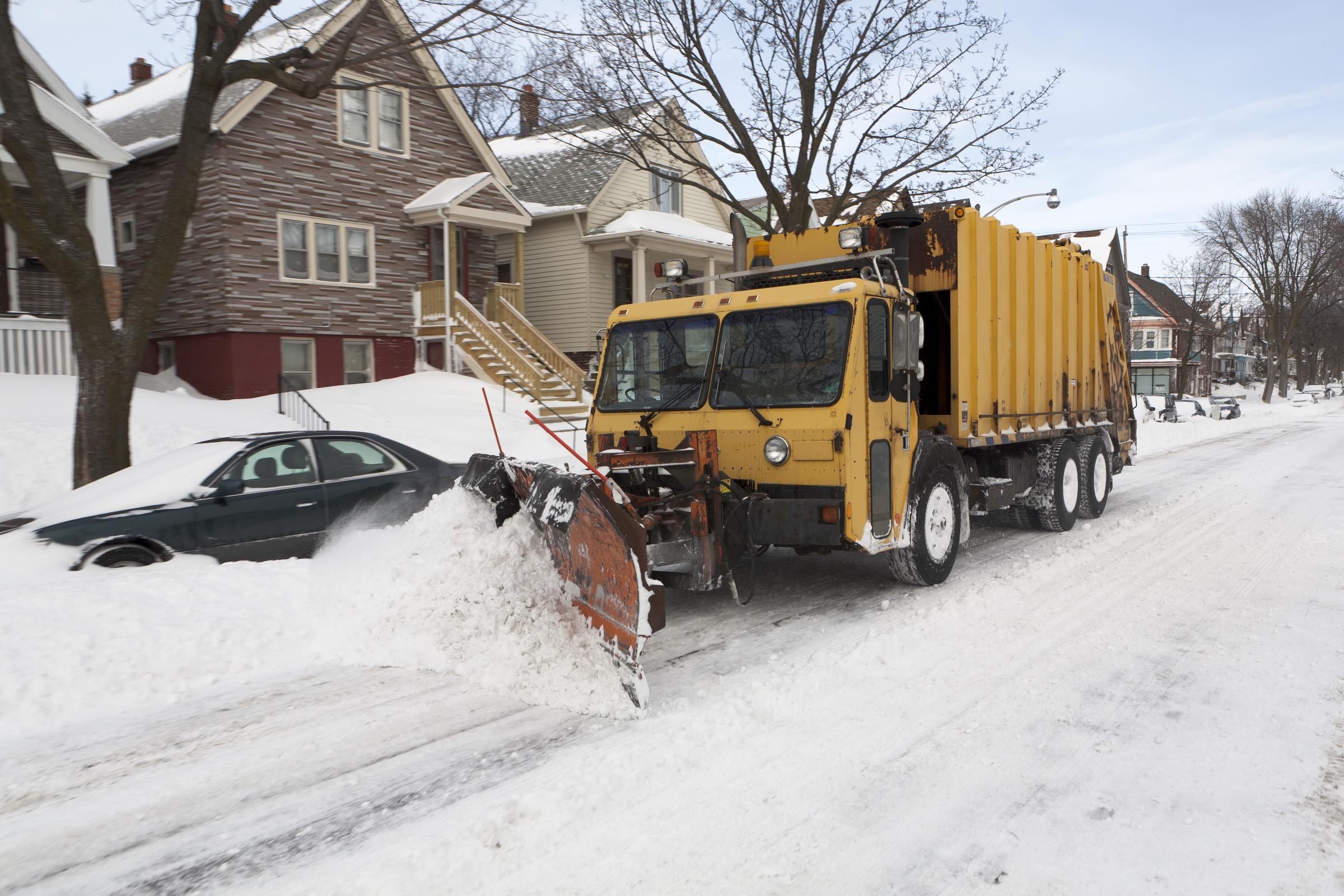 A garbage truck does double duty as a snowplow after a large winter storm in Wisconsin, dated February 7, 2011 | Source: Getty Images