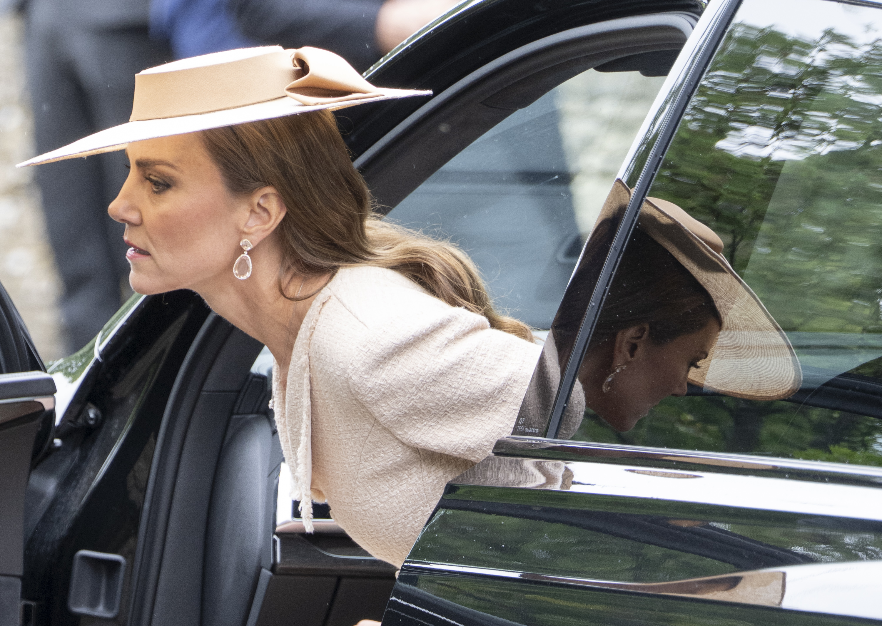 Catherine is seen stepping out of her car ahead of the ceremony, with her elegant cream ensemble and wide-brimmed hat reflected in the vehicle’s window. | Source: Getty Images