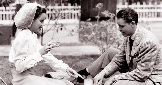​​Susan Peters and Richard Quine pictured having lunch al fresco on the set of the 1942 film "Tish." | Photo: Getty Images