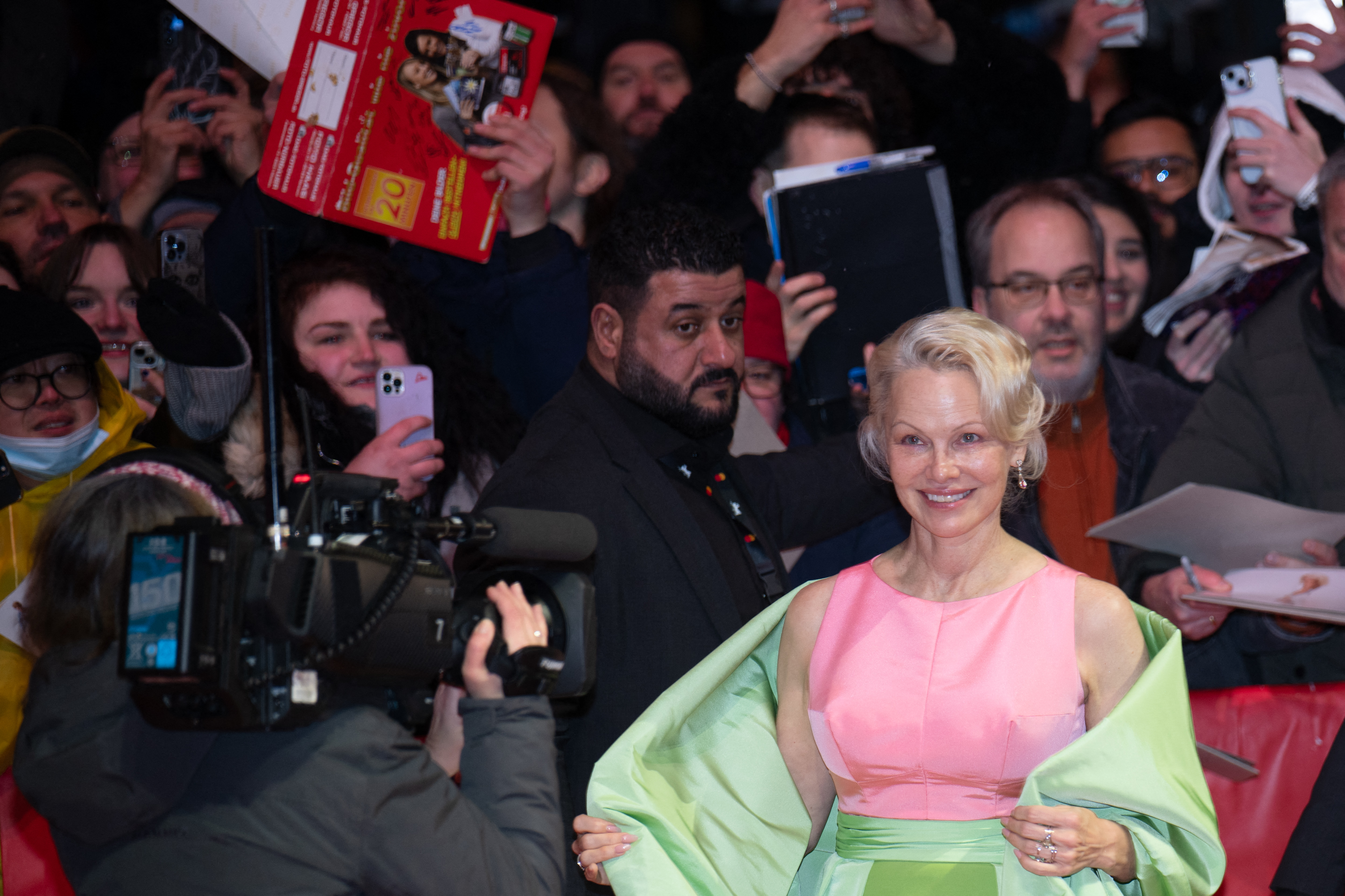 Pamela Anderson smiles while greeting fans and posing for cameras at the Berlin International Film Festival on February 14, 2026 | Source: Getty Images