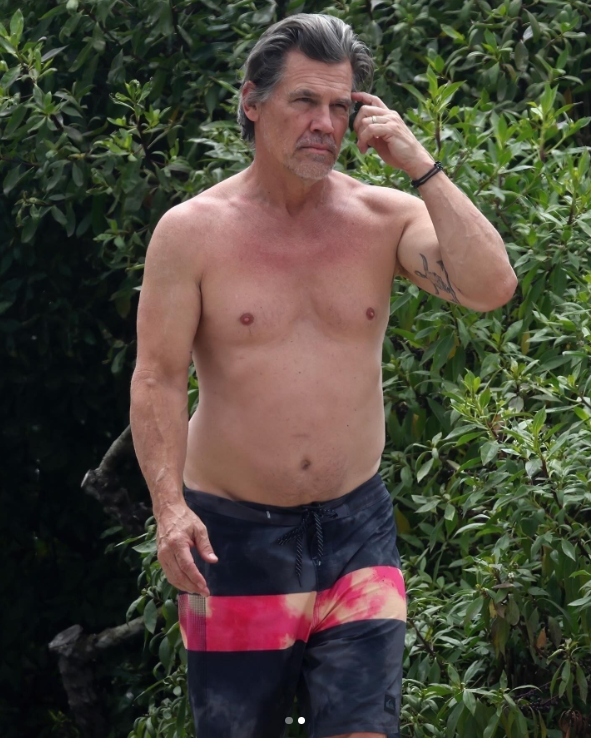 Josh Brolin, wearing black and red shorts, at a Santa Barbara beach in California, posted in July 2024 | Source: Instagram/justjared