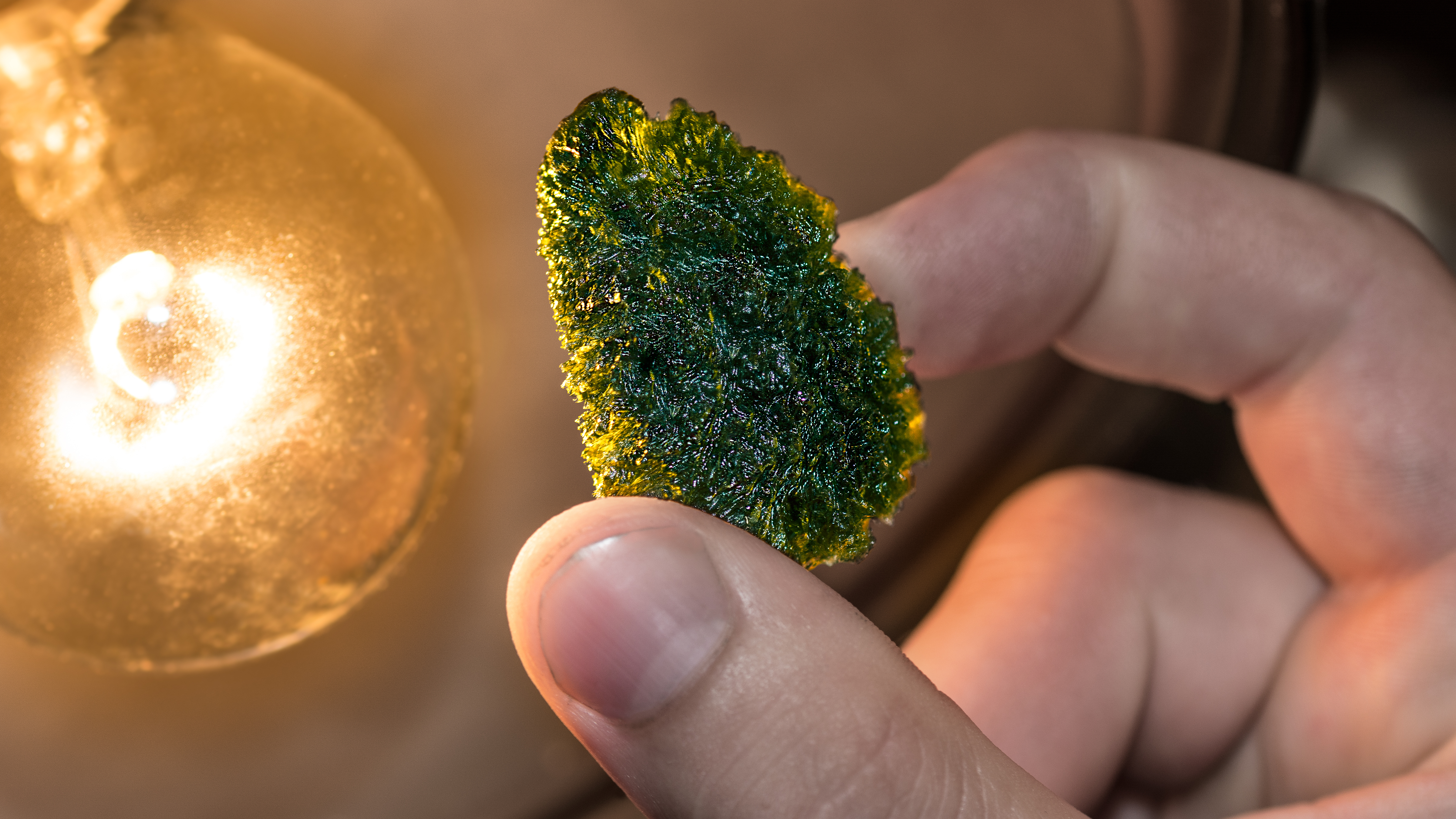 Photo of someone holding a piece of moldavite | Source: Getty Images