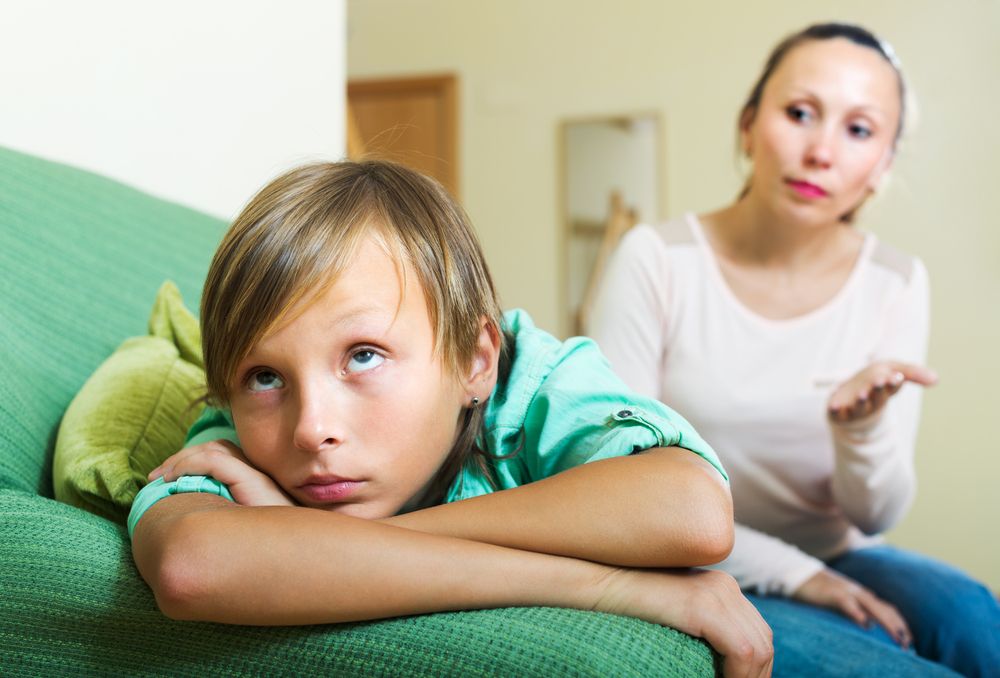 A young boy looking away while his mother talks to him. | Photo: Shutterstock