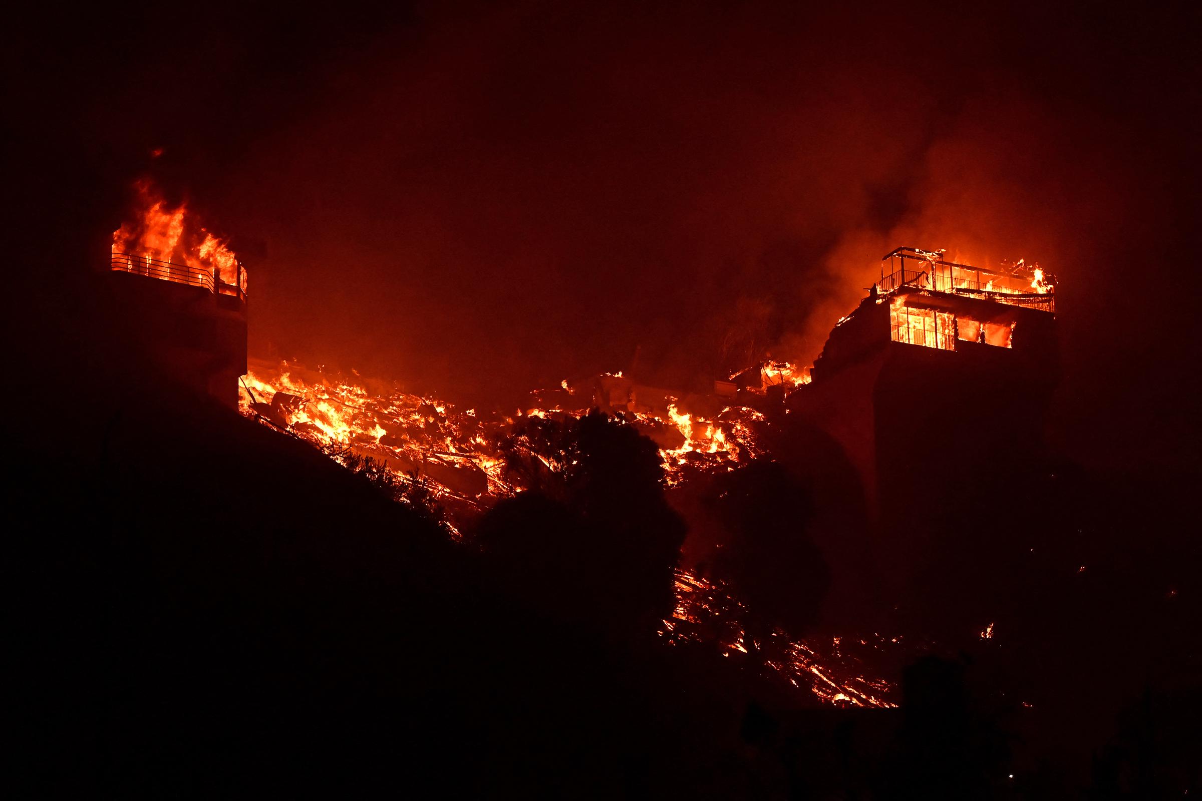 Structures burn along Pacific Coast Highway during the Palisades Fire in Malibu, California, on January 8, 2025 | Source: Getty Images