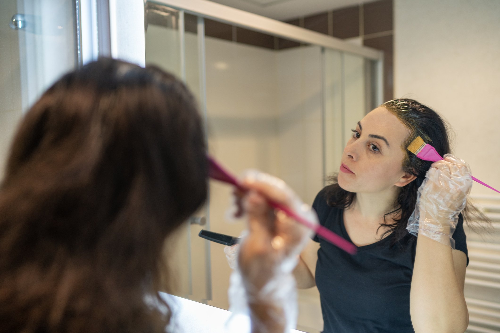 Une femme appliquant des teintures sur ses cheveux. | Photo : Getty Images Une femme appliquant des teintures sur ses cheveux. | Photo : Getty Images