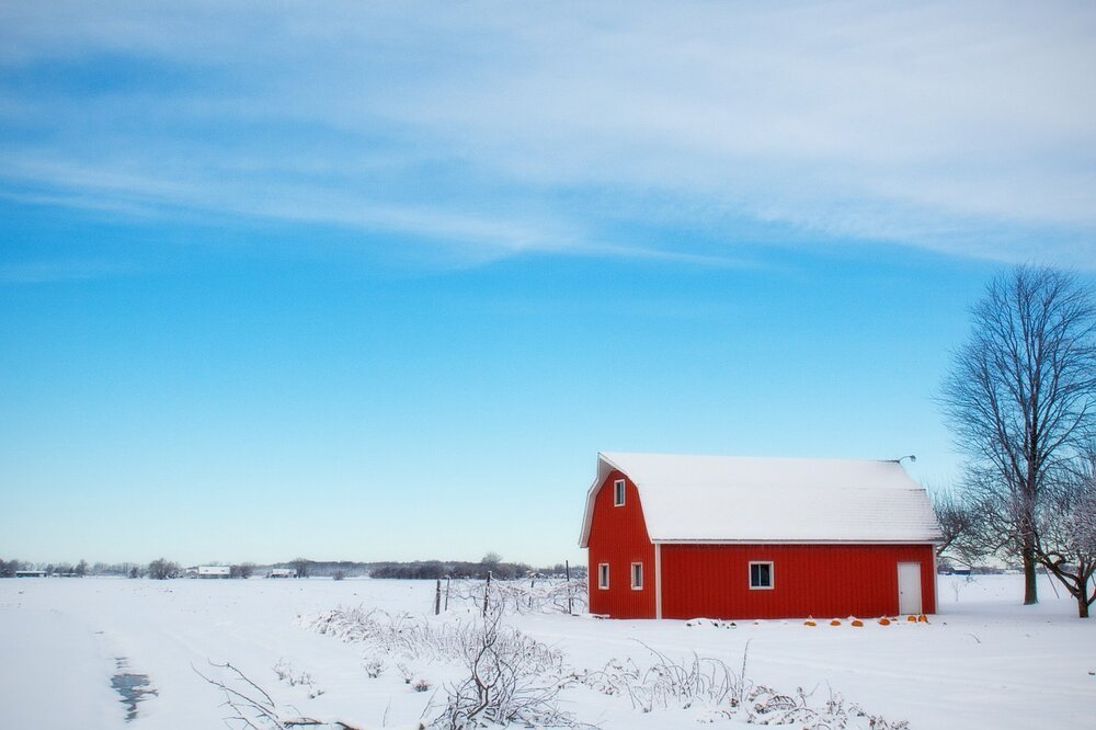 A barn in the middle of a snow-covered country landscape. | Photo: Pixabay.