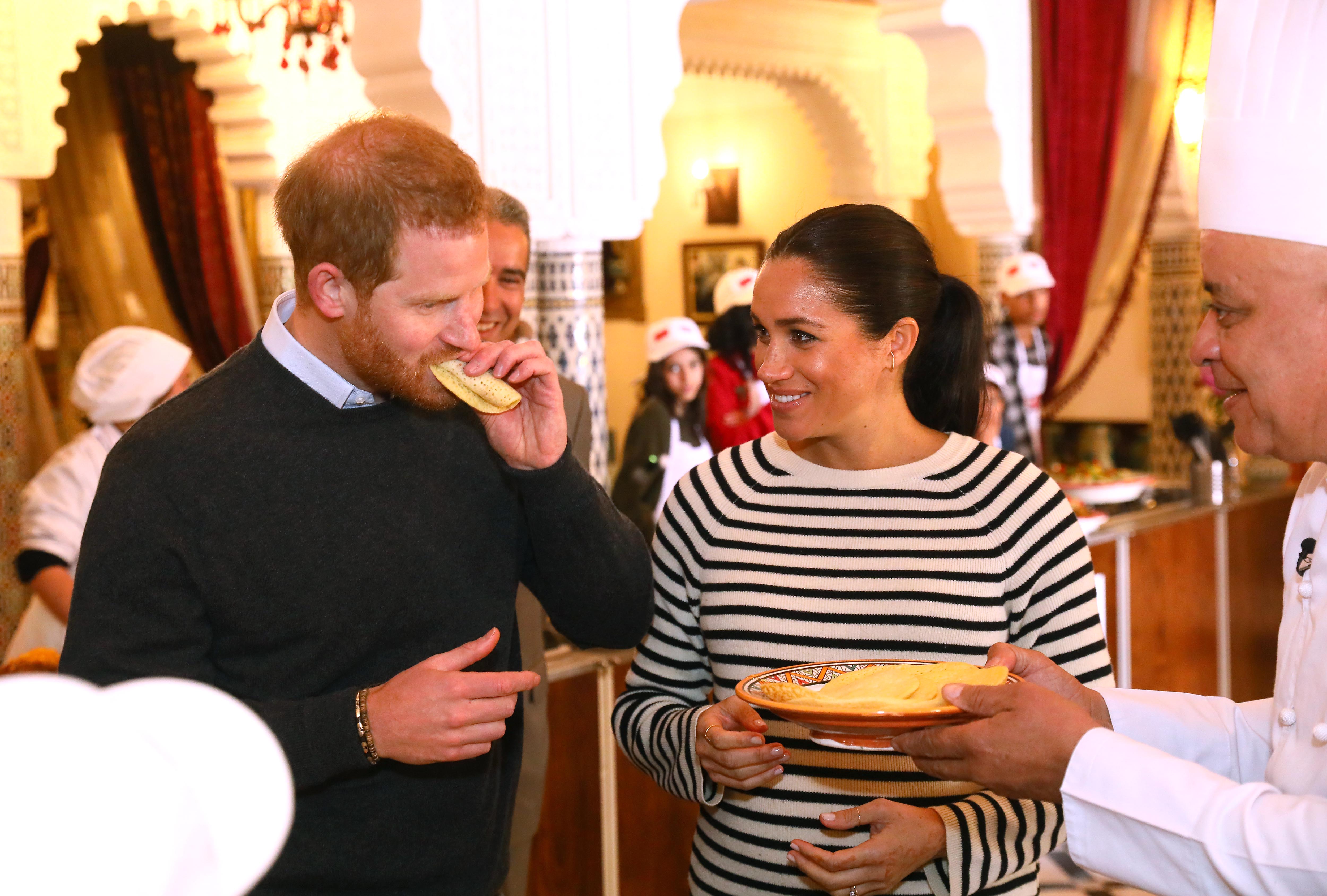 Prince Harry, Duke of Sussex and Meghan, Duchess of Sussex try some food as they visit a cooking demonstration at the Villa des Ambassadors in Rabat, Morocco, on February 25, 2019. | Source: Getty Images