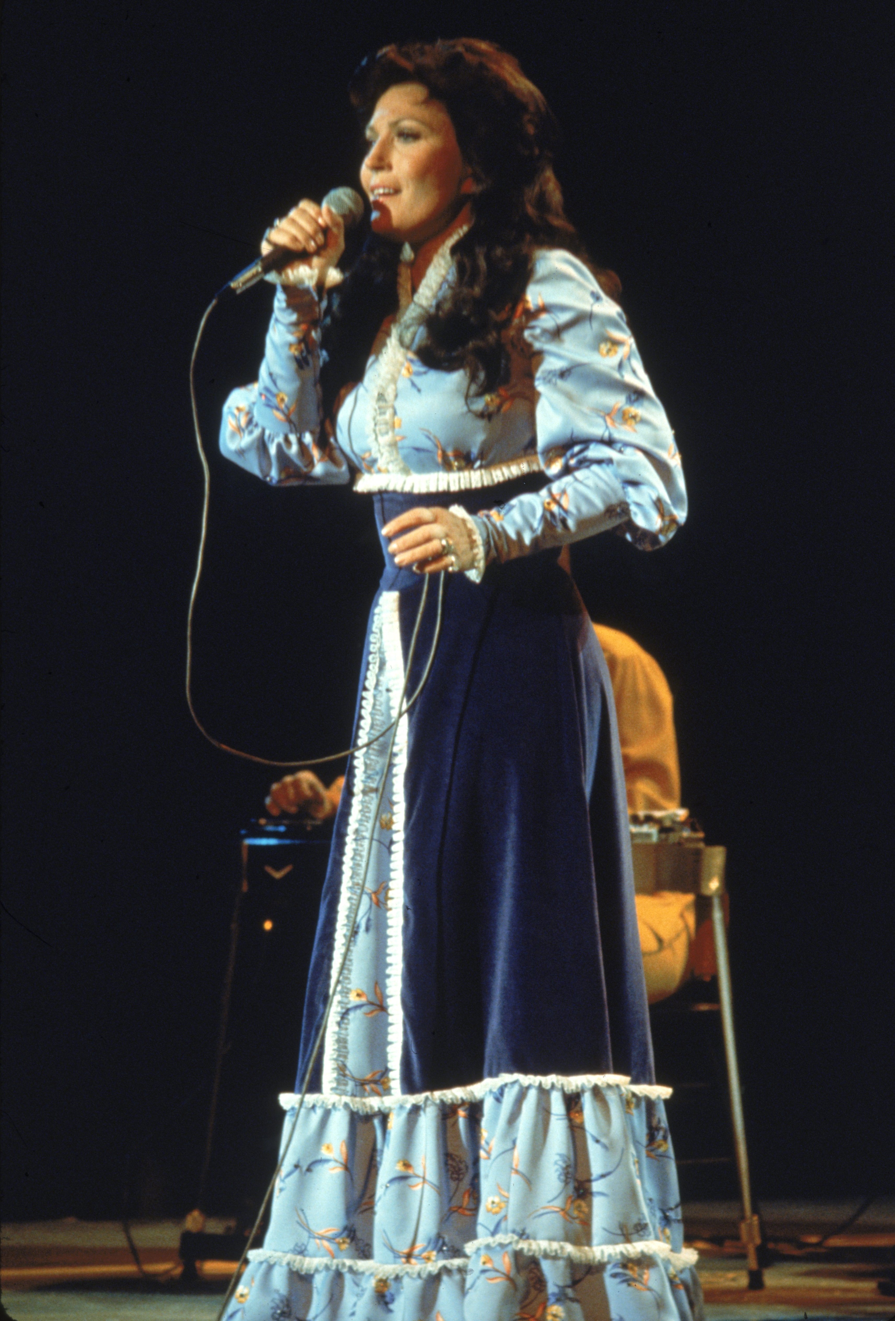 Loretta Lynn performs on stage, wearing a long dress in 1980. | Source: Getty Images