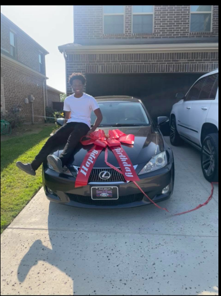 Karmelo Anthony sits on a Lexus adorned with a red gift bow in a photo taken before the events that led to his murder conviction. | Source: Facebook/Drew Anthony