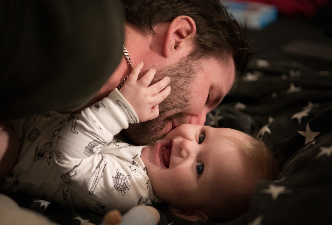 Un hombre le hace cosquillas cariñosas a su pequeña bebé. | Foto: Unsplash