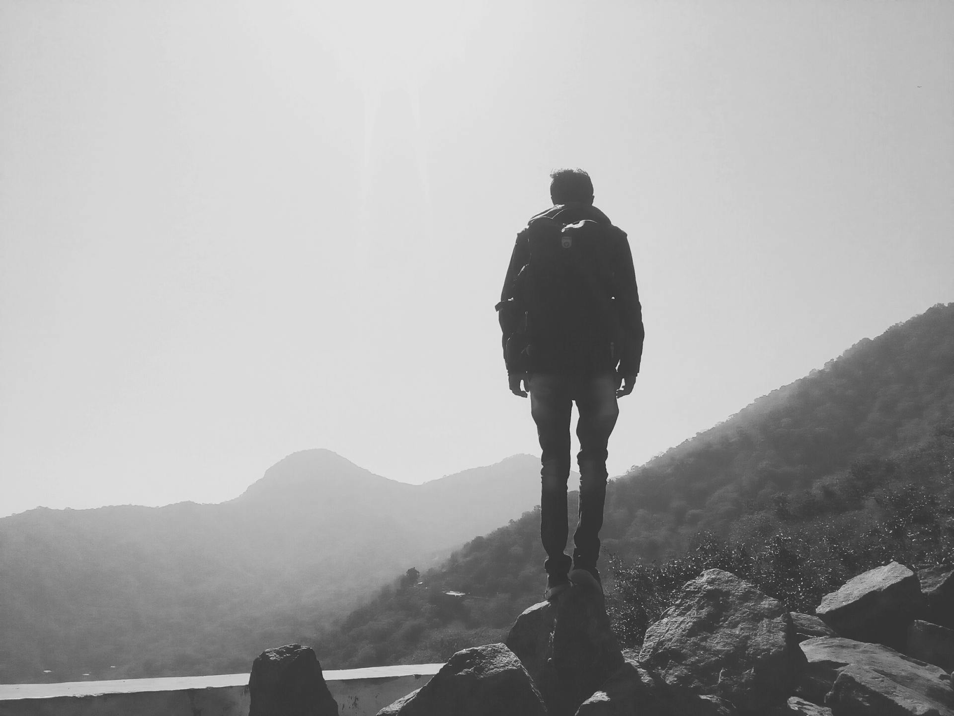 A person standing on a cliff with hiking gear | Source: Pexels