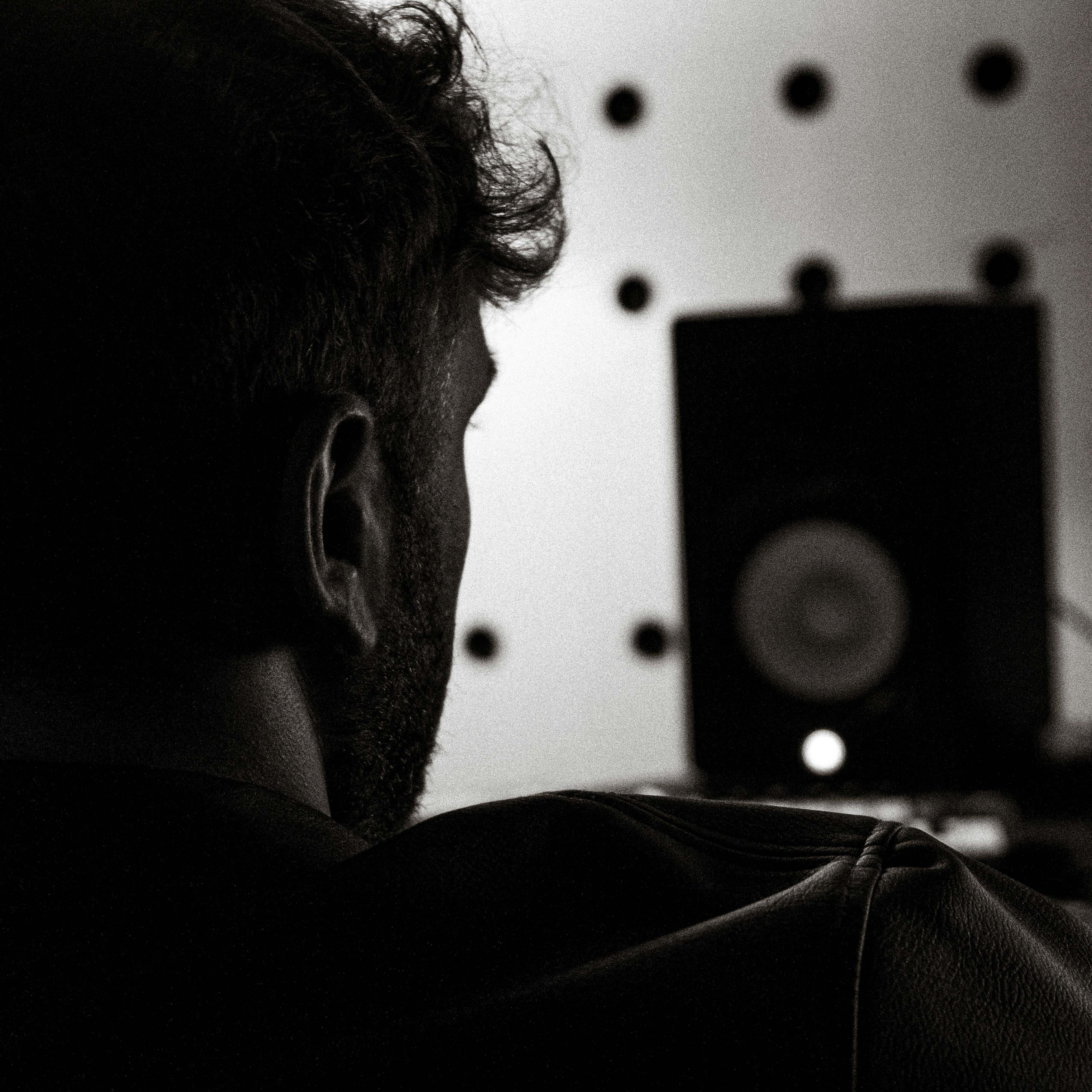 The silhouette of a man looking at a large speaker | Source: Pexels