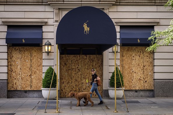 A pedestrian walks a dog past a Ralph Lauren store on Michigan Avenue in Chicago, Illinois on Friday, June 5, 2020. | Photo: Getty Images