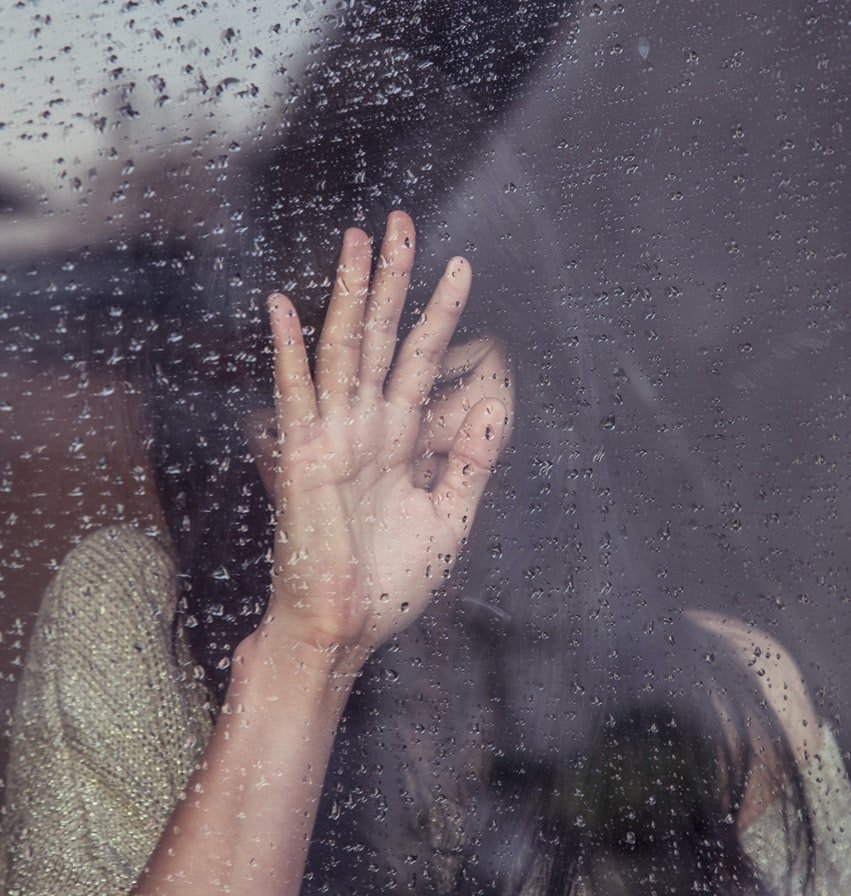 Mujer llora recostada a una ventana un día lluvioso. | Foto: Unsplash