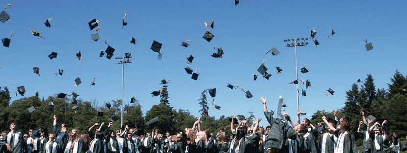 A photo of graduates with their caps thrown in the air in celebration | Source: Pixabay